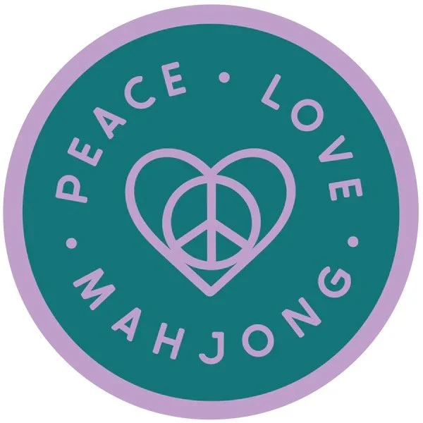 A circular emblem with a purple border and teal background. Inside, there is a purple heart intertwined with a peace sign. Around the heart, the words 'PEACE', 'LOVE', and 'MAHJONG' are written in purple, separated by small dots.
