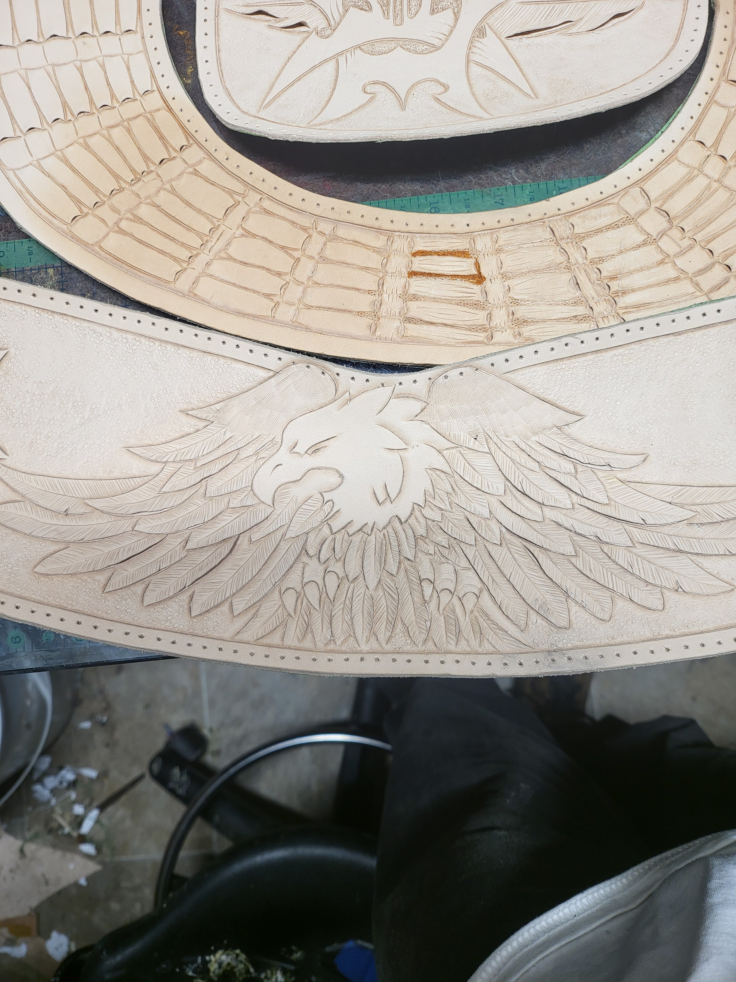 Wooden artwork featuring an eagle with spread wings and a fierce expression, carved with intricate feather details.