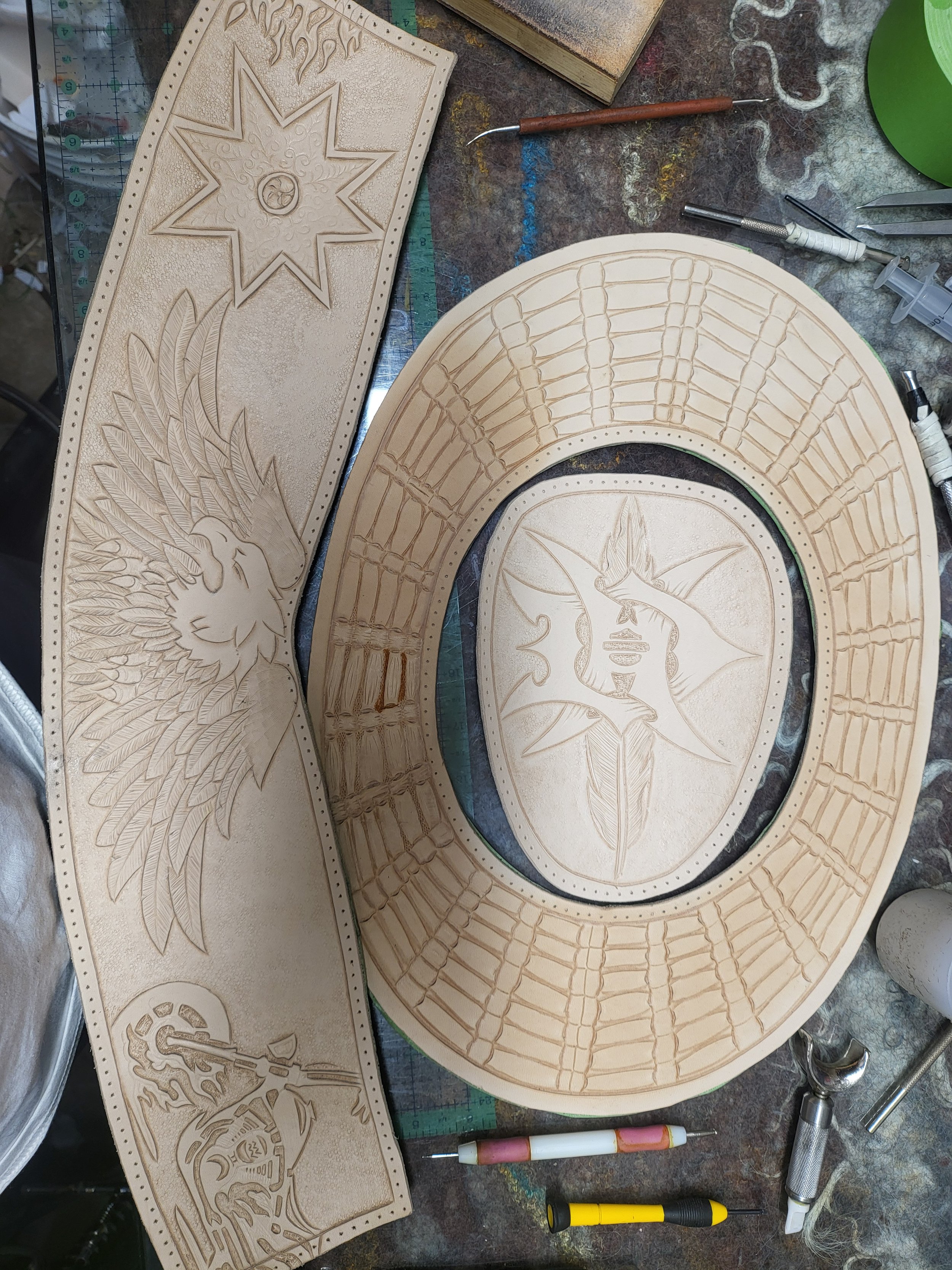 Wooden art pieces featuring intricate carvings of a eagle, a hummingbird, and a shield with a face, surrounded by geometric and decorative patterns.