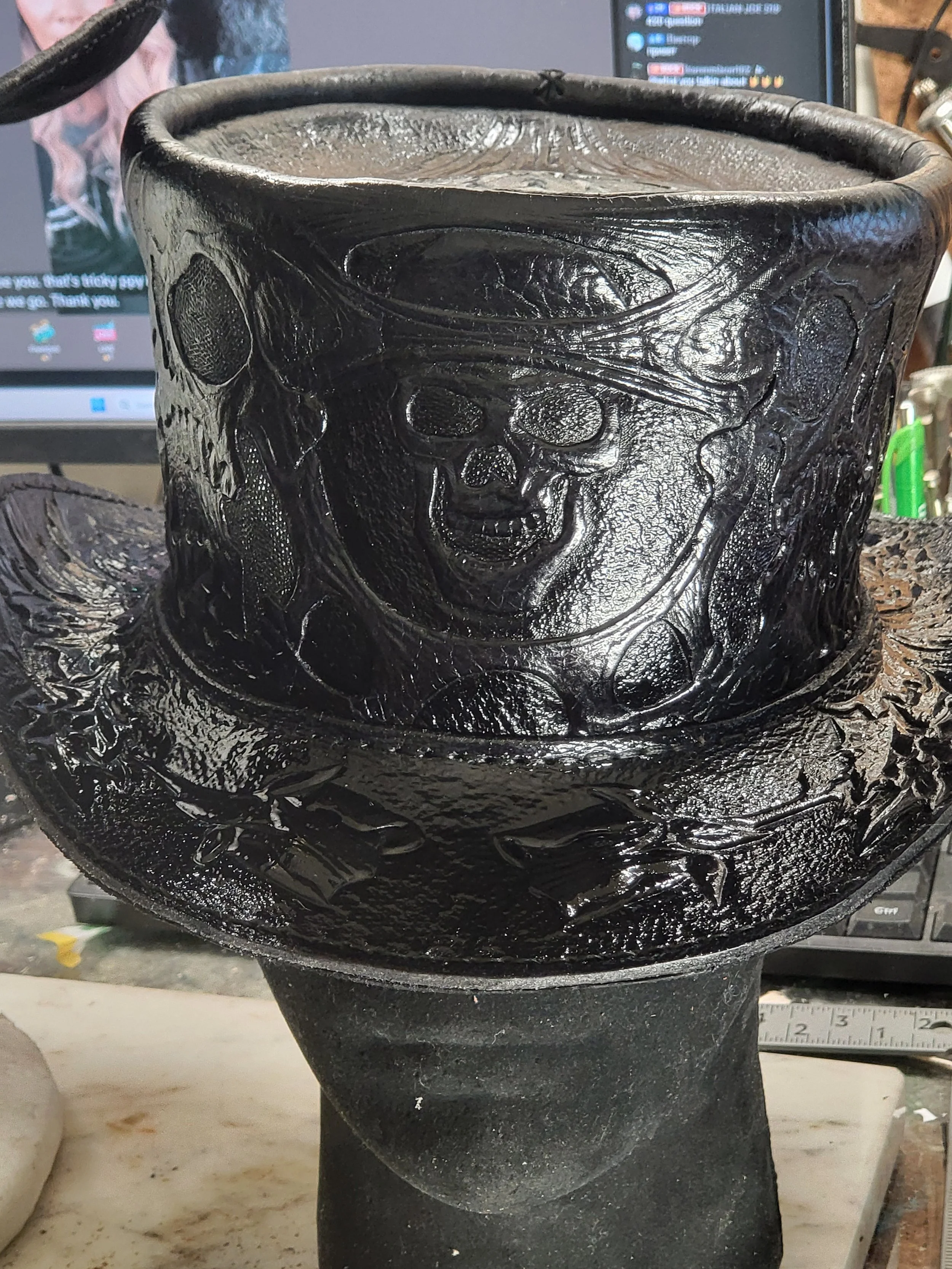 A black ceramic skull with a cowboy hat design, featuring detailed textured skull and facial features.