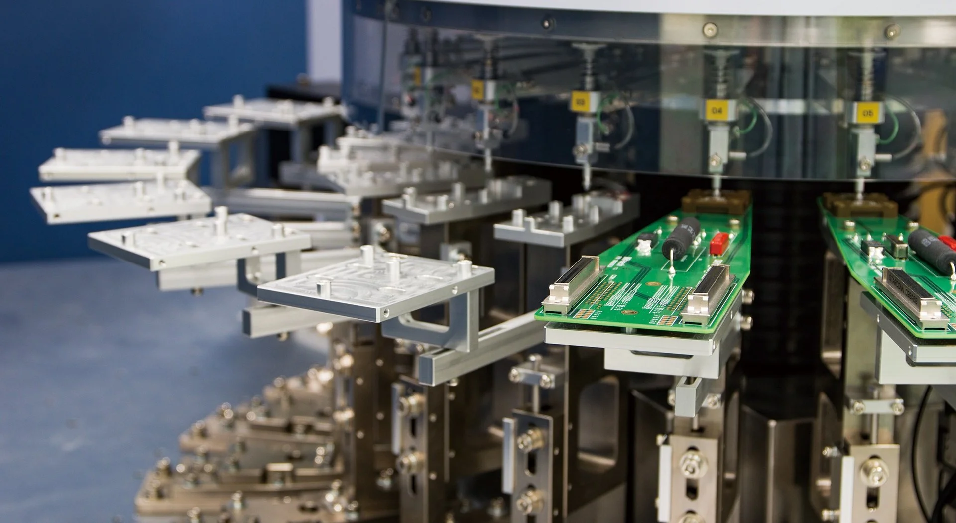 Assembly line with circuit boards and electronic components in a factory setting.