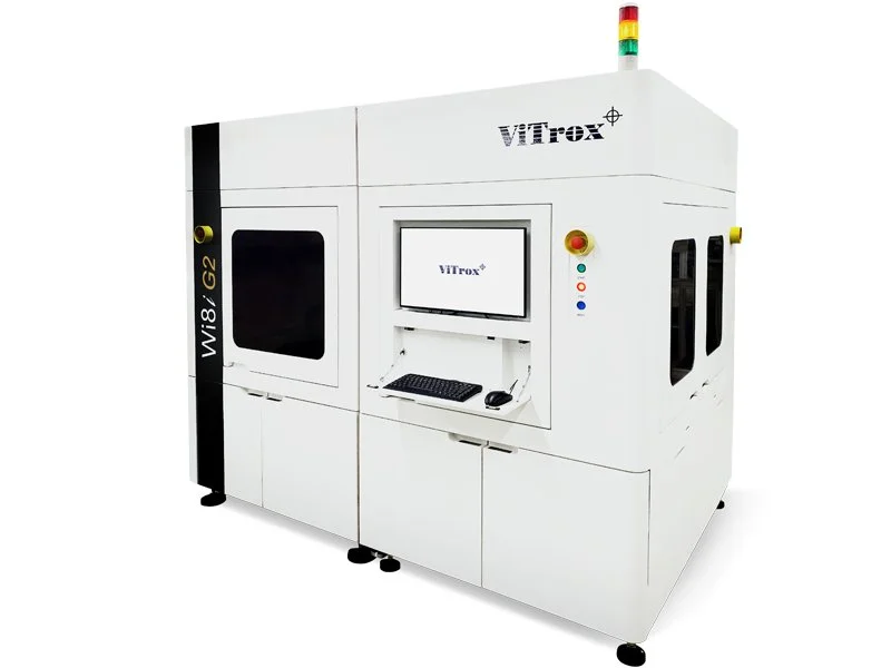 Large white industrial machine with a computer monitor, keyboard, and mouse inside a security enclosure, labeled WLi8 G2, with lights and controls on the side, branded with ViTrox.