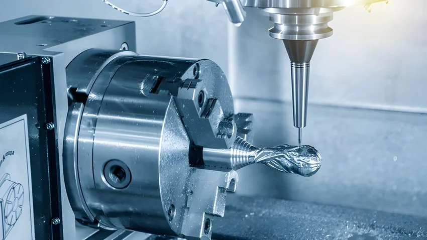 A CNC machine milling a shiny metal piece, with the spindle and cutting tool actively shaping the metal.