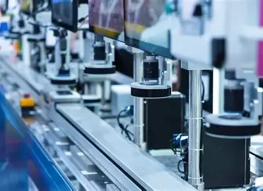 A row of automated machines and conveyor belts in a high-tech manufacturing or assembly plant.