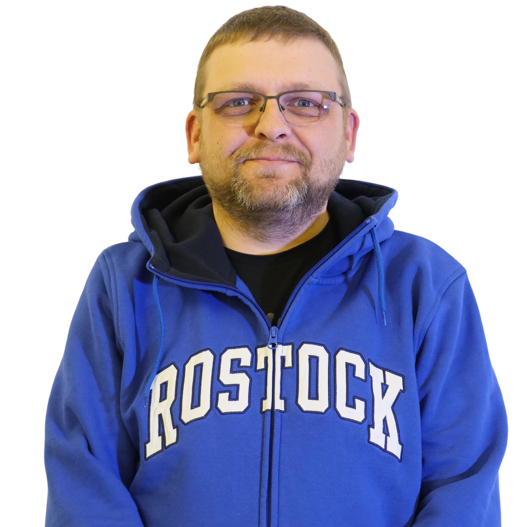 Porträt eines Mannes mit Brille, braunem Haar und Bart, trägt einen blauen Hoodie mit weißen Buchstaben auf der Vorderseite. Hintergrund weiß.