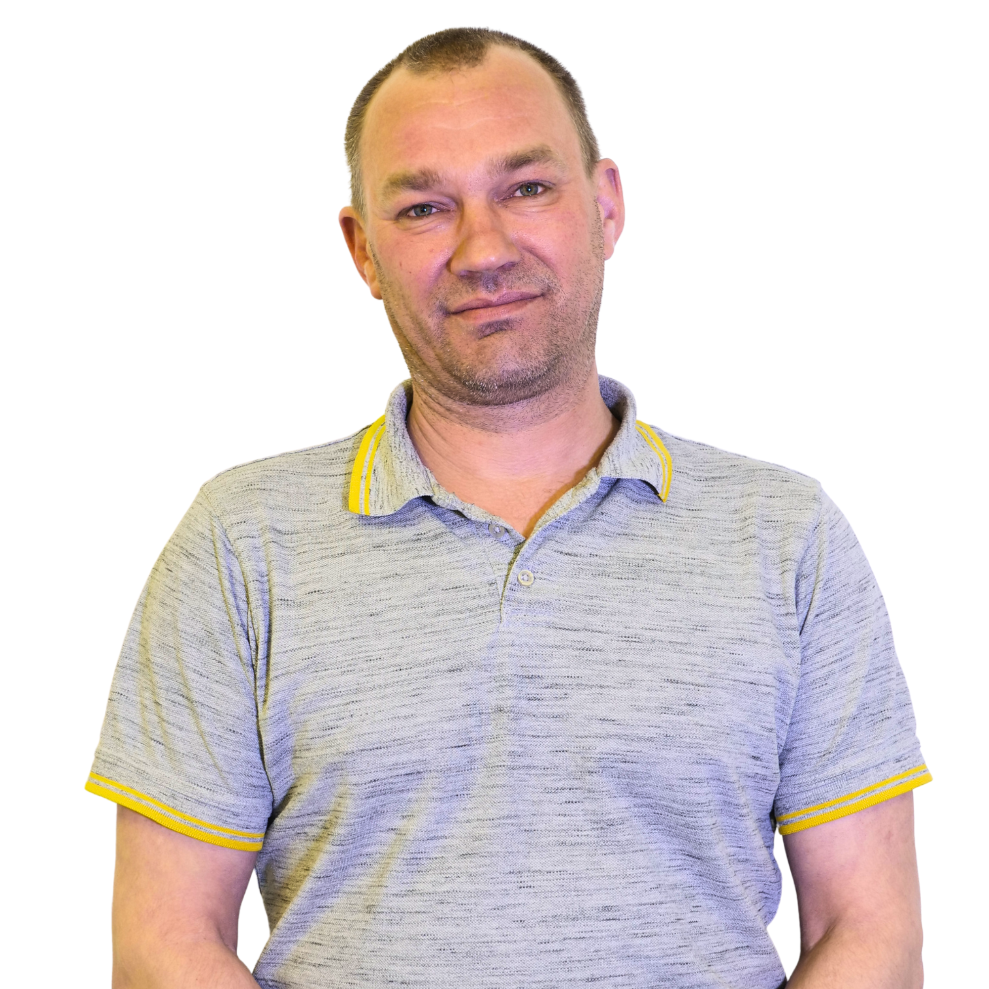 Porträt eines Mannes mit kurzhaarigem Haar, blauen Augen und leichtem Bart, tragt ein grau-blau gestreiftes Polo-Shirt mit gelben Akzenten, vor weißem Hintergrund.
