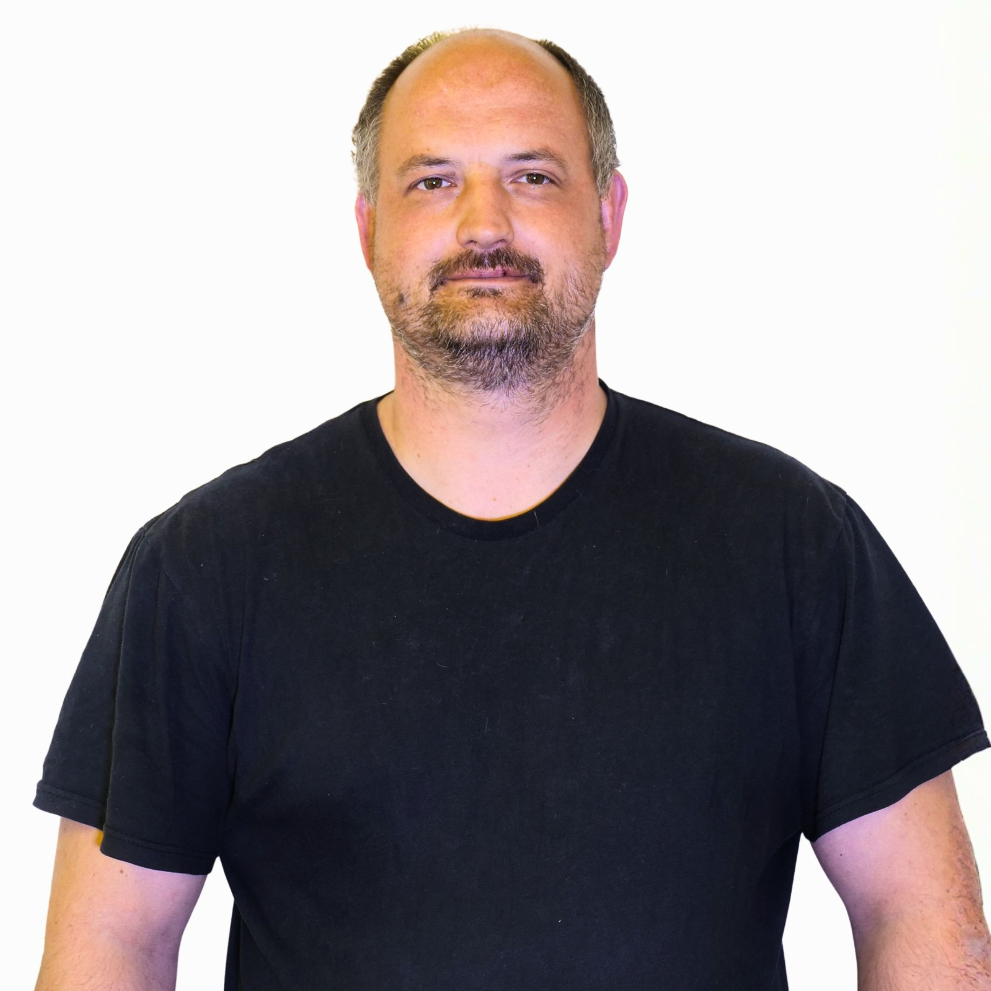 Nahaufnahme eines Mannes mit dunklem T-Shirt vor weißem Hintergrund.