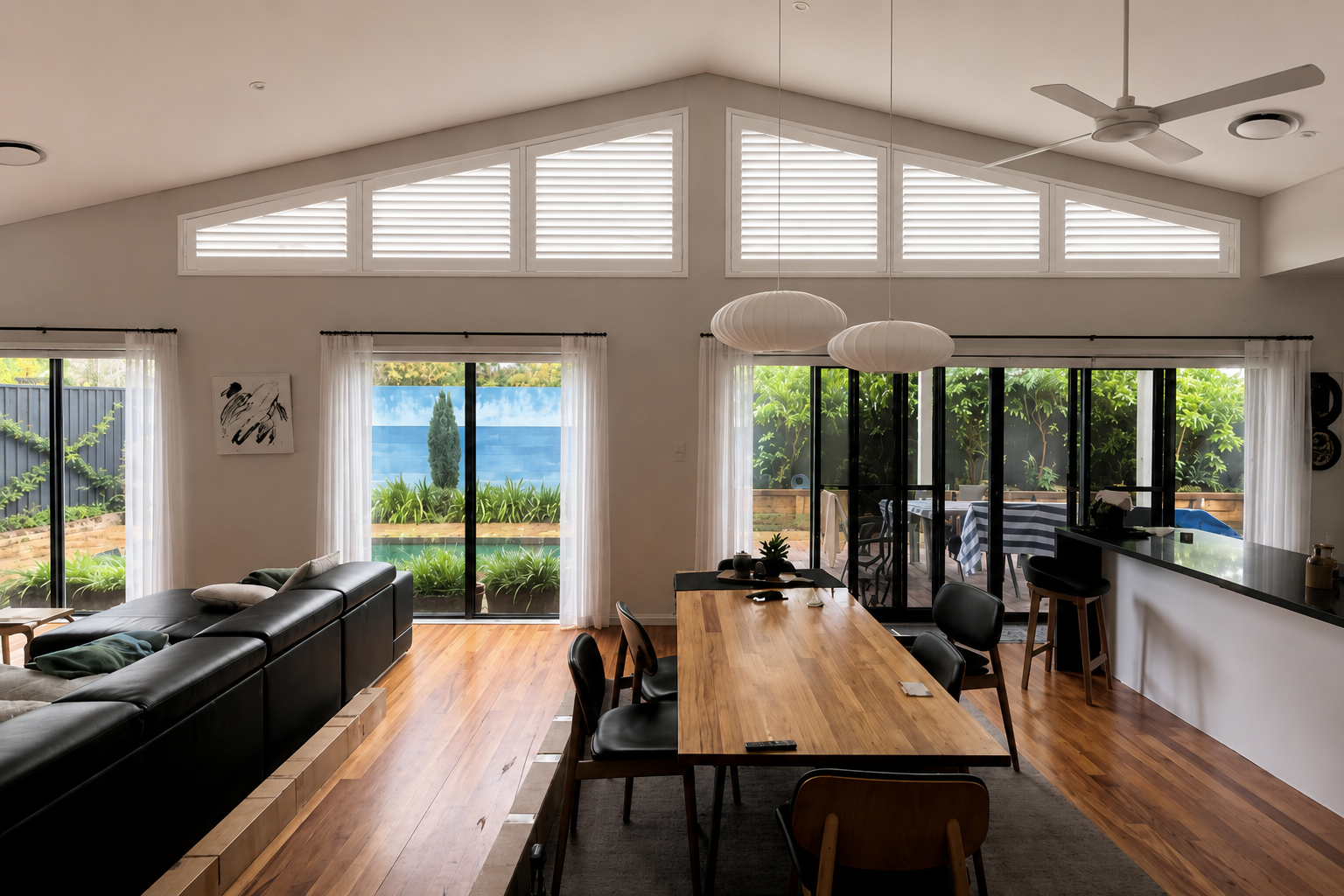 AI preview showing Basswood Timber Superspan plantation shutters with six panels across shaped windows in Oran Park.