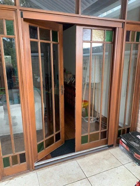 Custom pleated retractable fly screen installed on timber French doors in open position