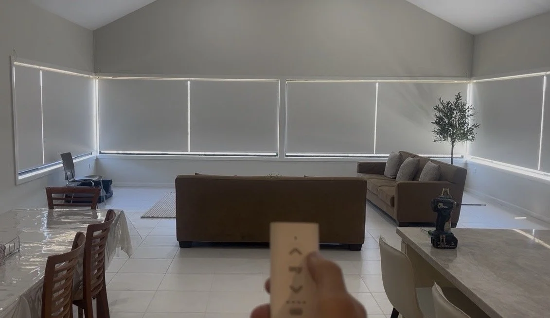Motorised roller blinds operated using a remote control in a modern family room