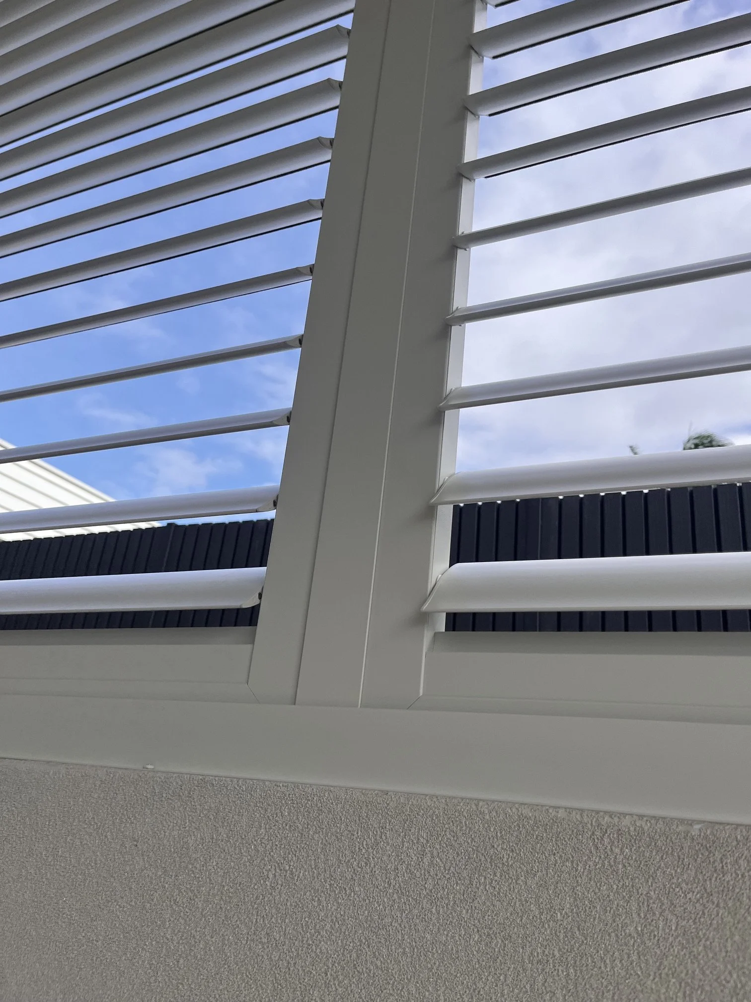Close-up detail of Slimline Series outdoor shutters showing mitred corners and hidden tilt operation