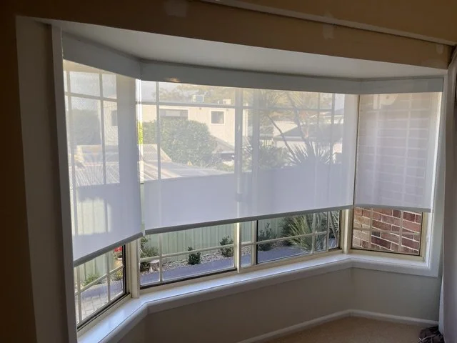 Sunscreen Roller Blinds in Kleenscreen Pure White fabric with aluminium fascia's in bay window