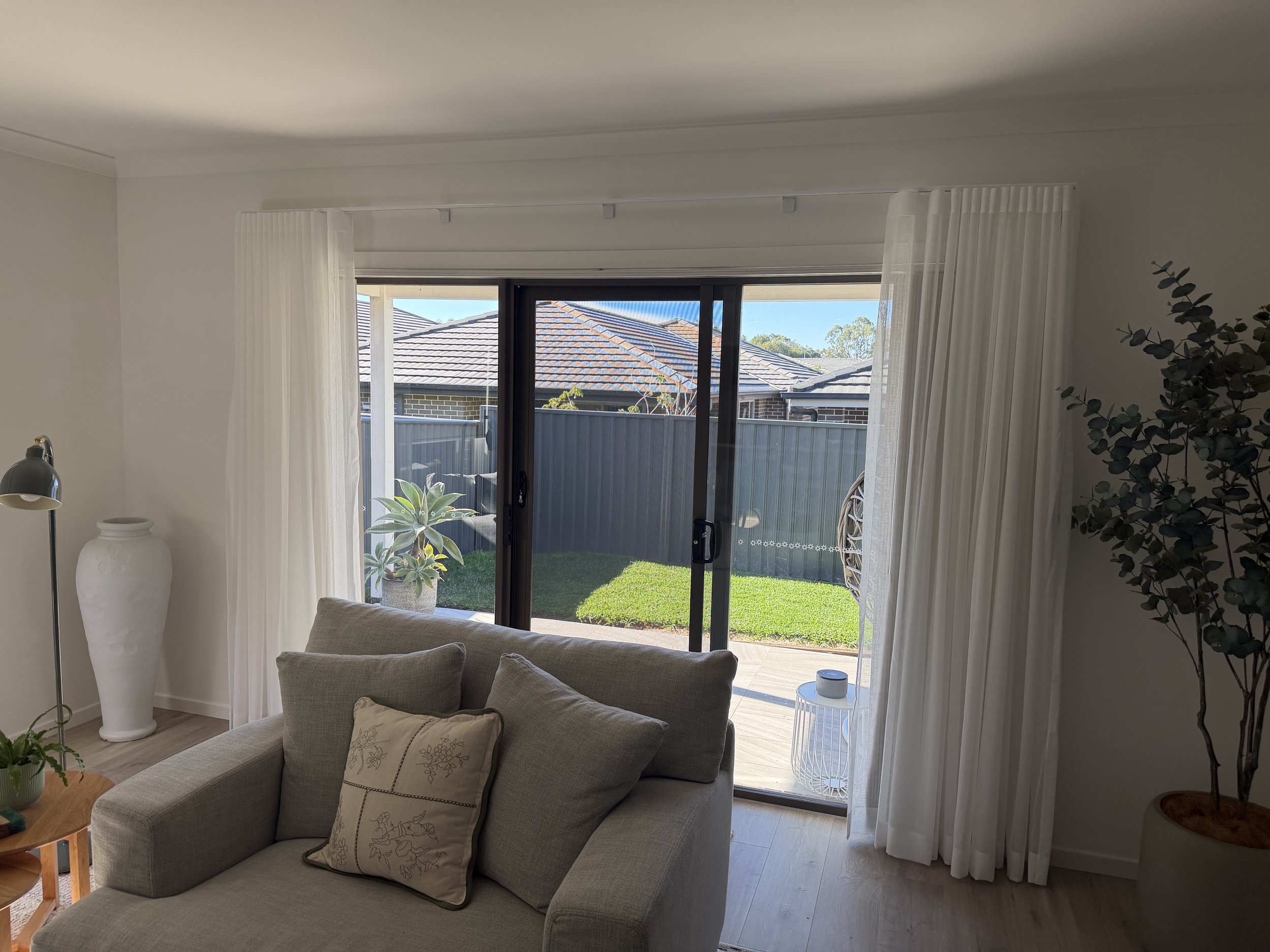 Clean look of a Sliding Supascreen Security Door in Jasper colour and S-Wave Curtains to further soften the room.