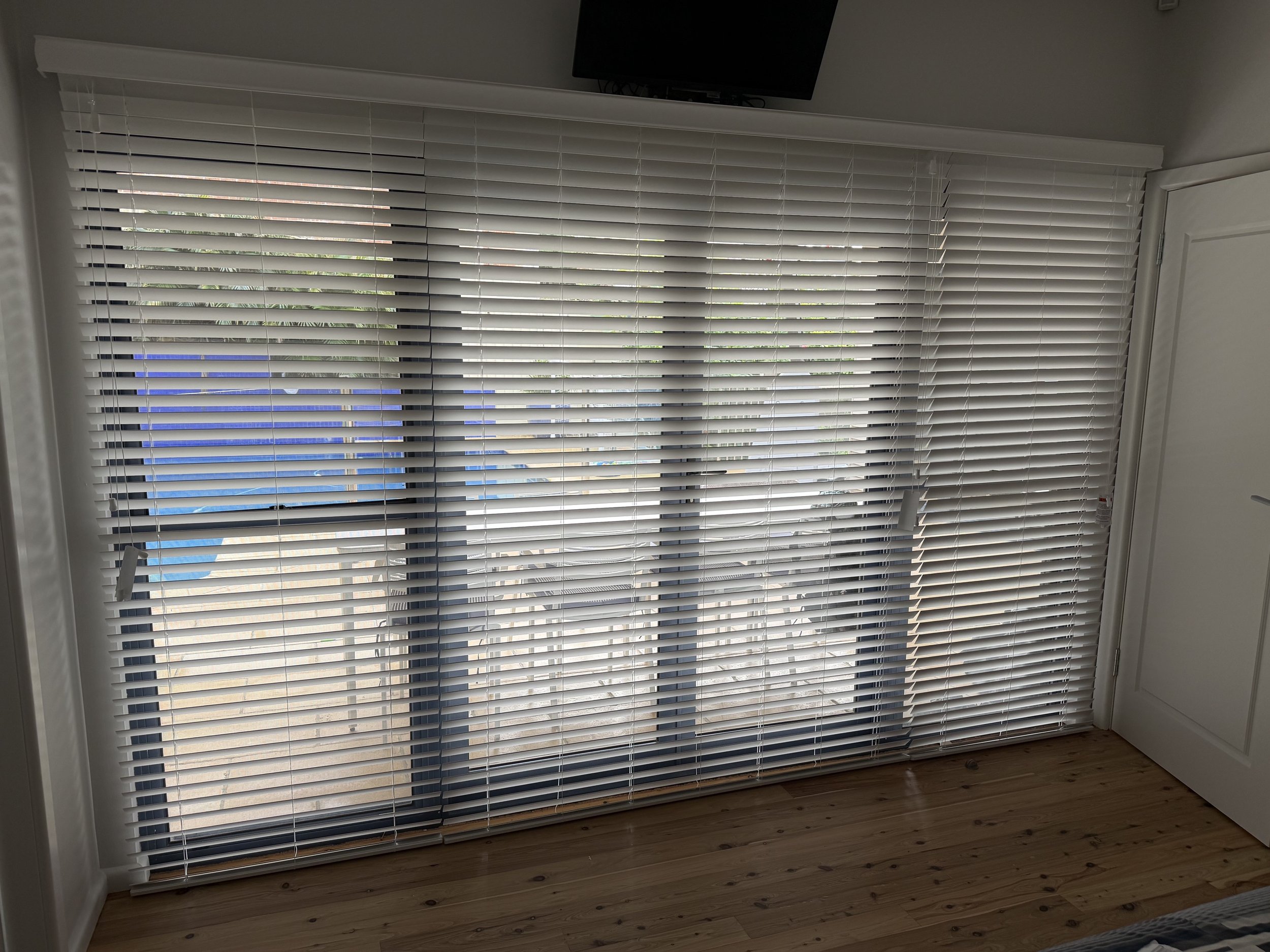PVC Venetian blinds tilted to provide privacy while allowing natural light to filter through.