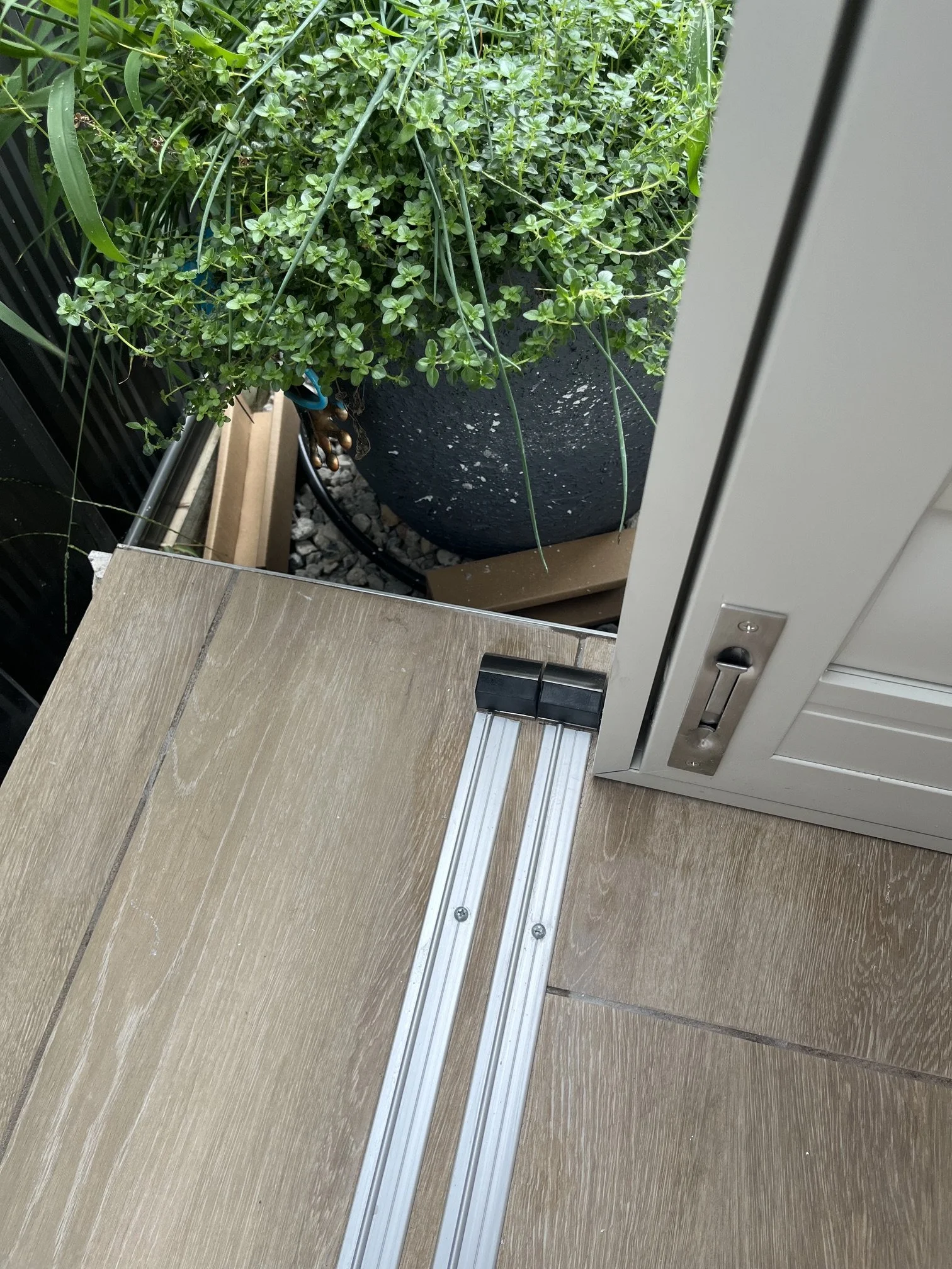 Bottom track detail of sliding outdoor aluminium shutters installed in Elderslie.