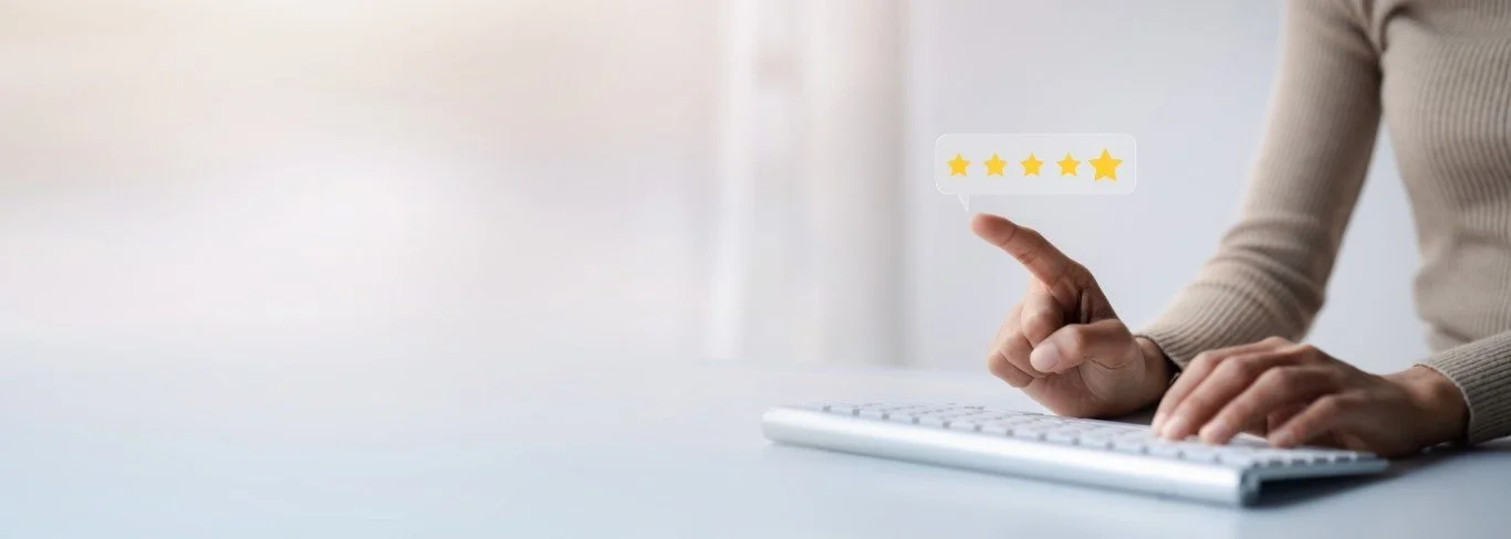 Une personne utilisant un clavier d'ordinateur, pointant vers une évaluation 5 étoiles flottante.