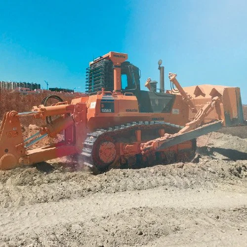 Escavadeira de construção em terreno de obra sob céu azul