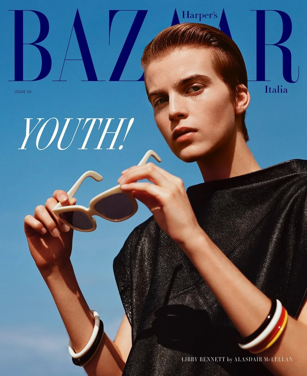 Cover of Harper's Bazaar Italia featuring Libby Bennett, with a young woman holding sunglasses and wearing black clothing against a clear blue sky.