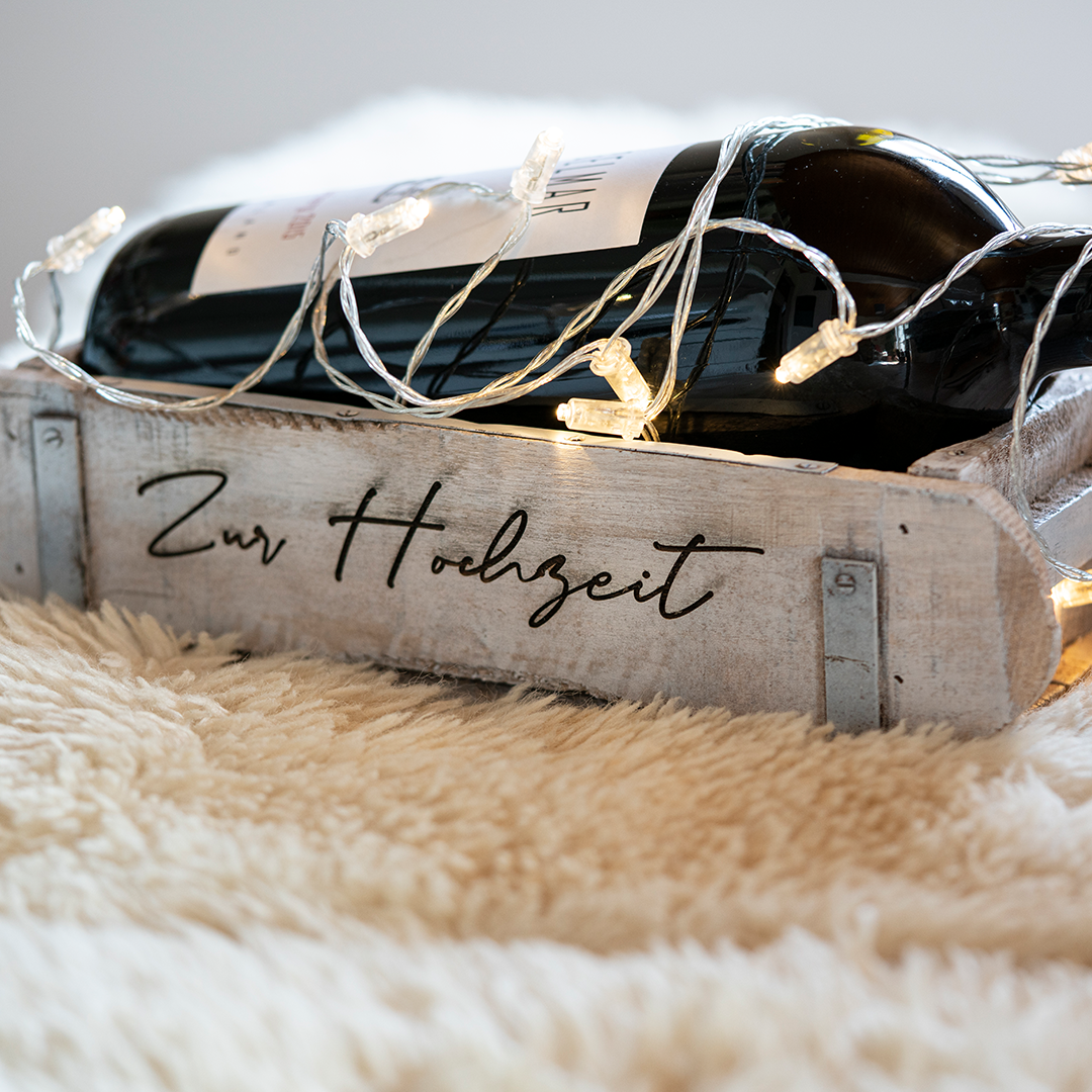 Holzkiste mit lasergravierter Aufschrift Zur Hochzeit, Weinflasche und Lichterkette als Hochzeitsgeschenk