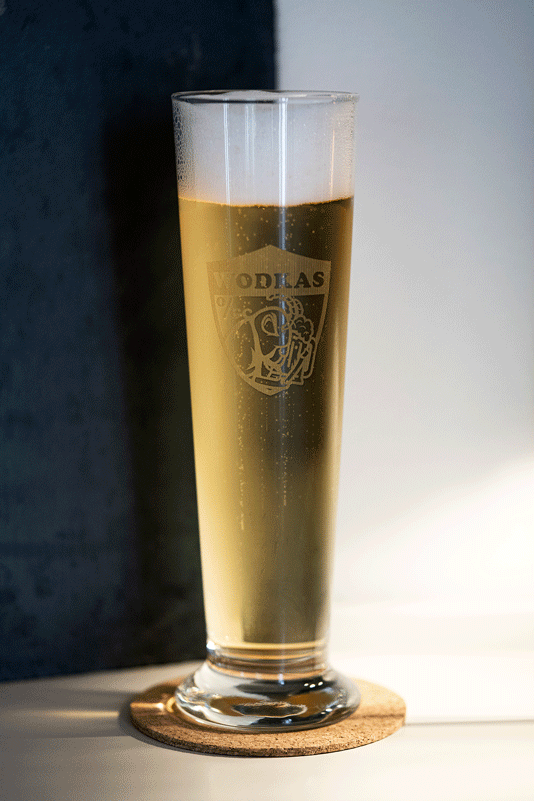 Bierglas mit lasergraviertem Wappen, gefüllt mit Bier auf Korkuntersetzer