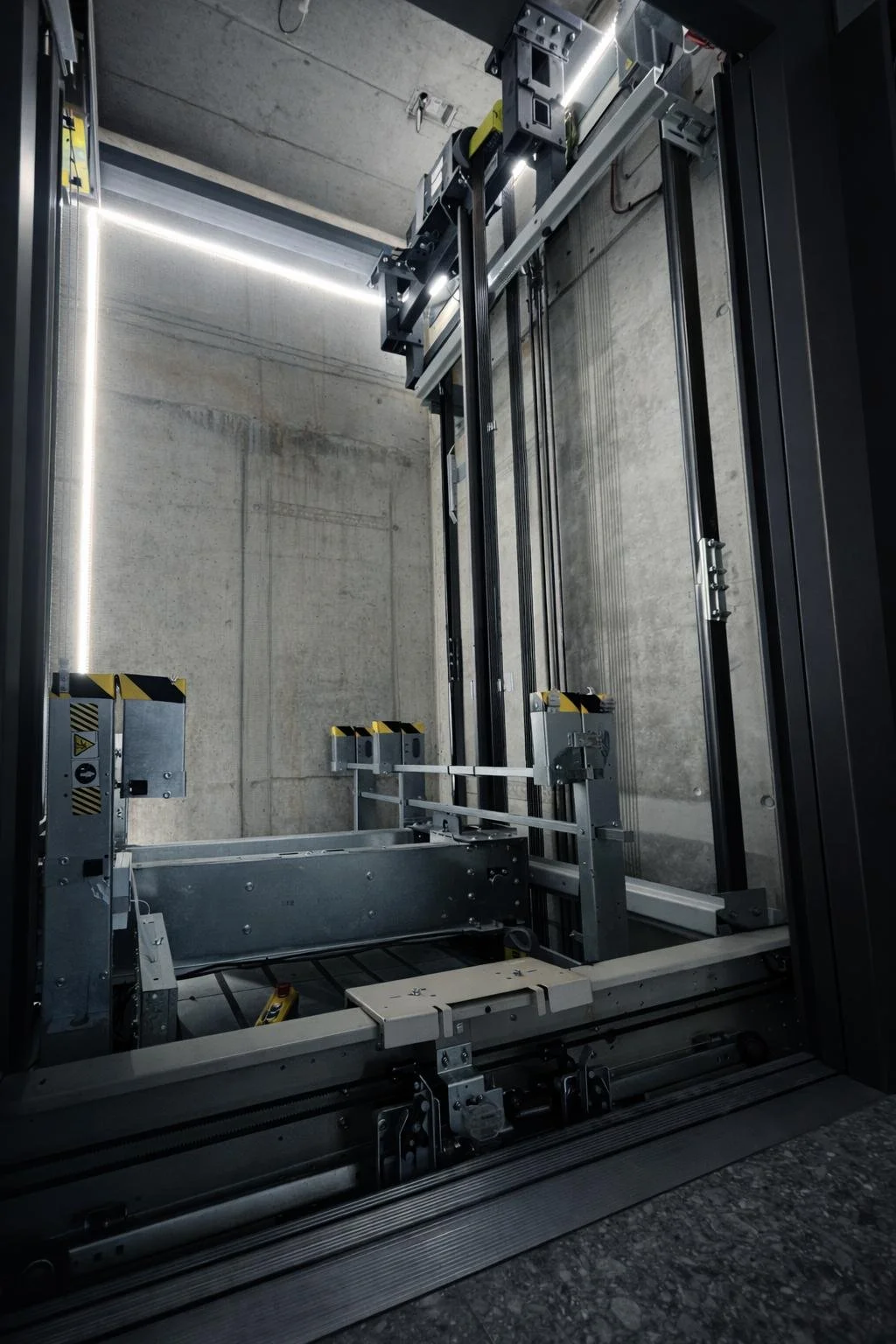 Leerer Aufzugsschacht mit sichtbaren mechanischen und elektrischen Komponenten