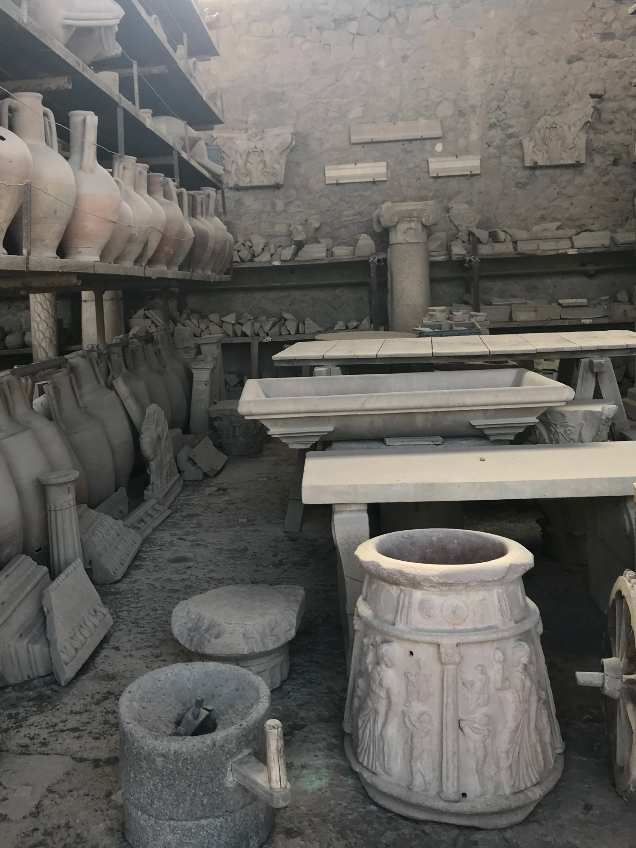 Historischer Museumsraum mit antiken Säulen, Vasen und Steinmetz-Werkzeugen.