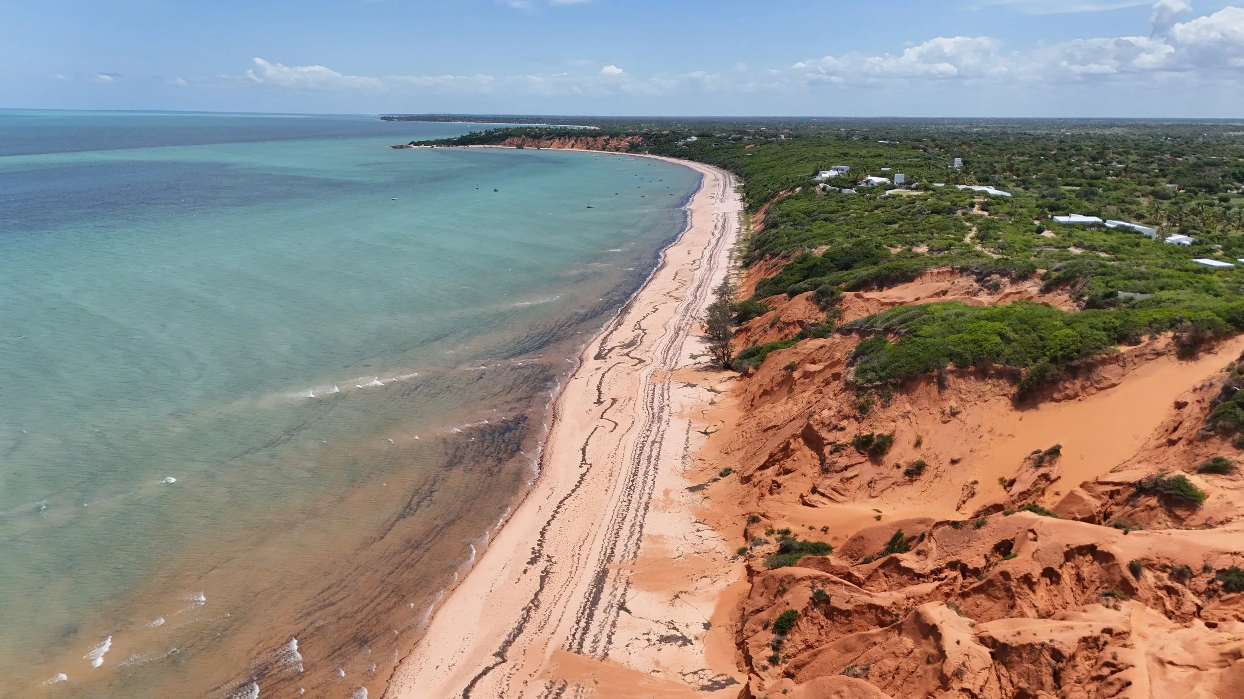 Photo divisée en deux parties montrant deux paysages: à gauche, un paysage désertique avec montagnes arides, un fleuve et quelques végétations, sous un ciel clair; à droite, une vue aérienne d'une ville côtière avec de nombreux immeubles, des terrains de sport, la mer et une côte avec un stade géant, sous un ciel en partie nuageux.