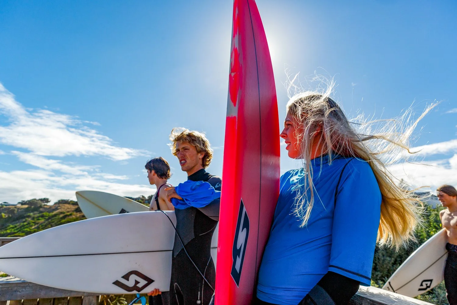 Group of young surfers holding surfboards. School and event photography by Jess Grant and Alys Carr, Melbourne Australia.