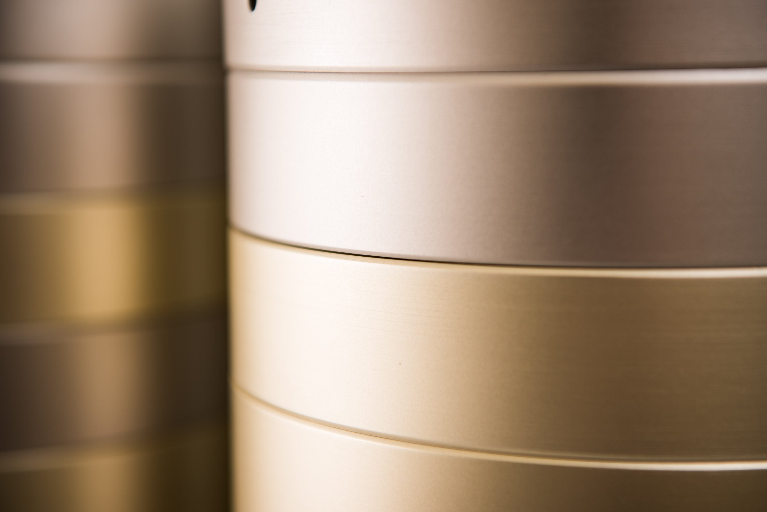 Close-up of stacked metallic storage containers or tins with a smooth finish and rounded edges.