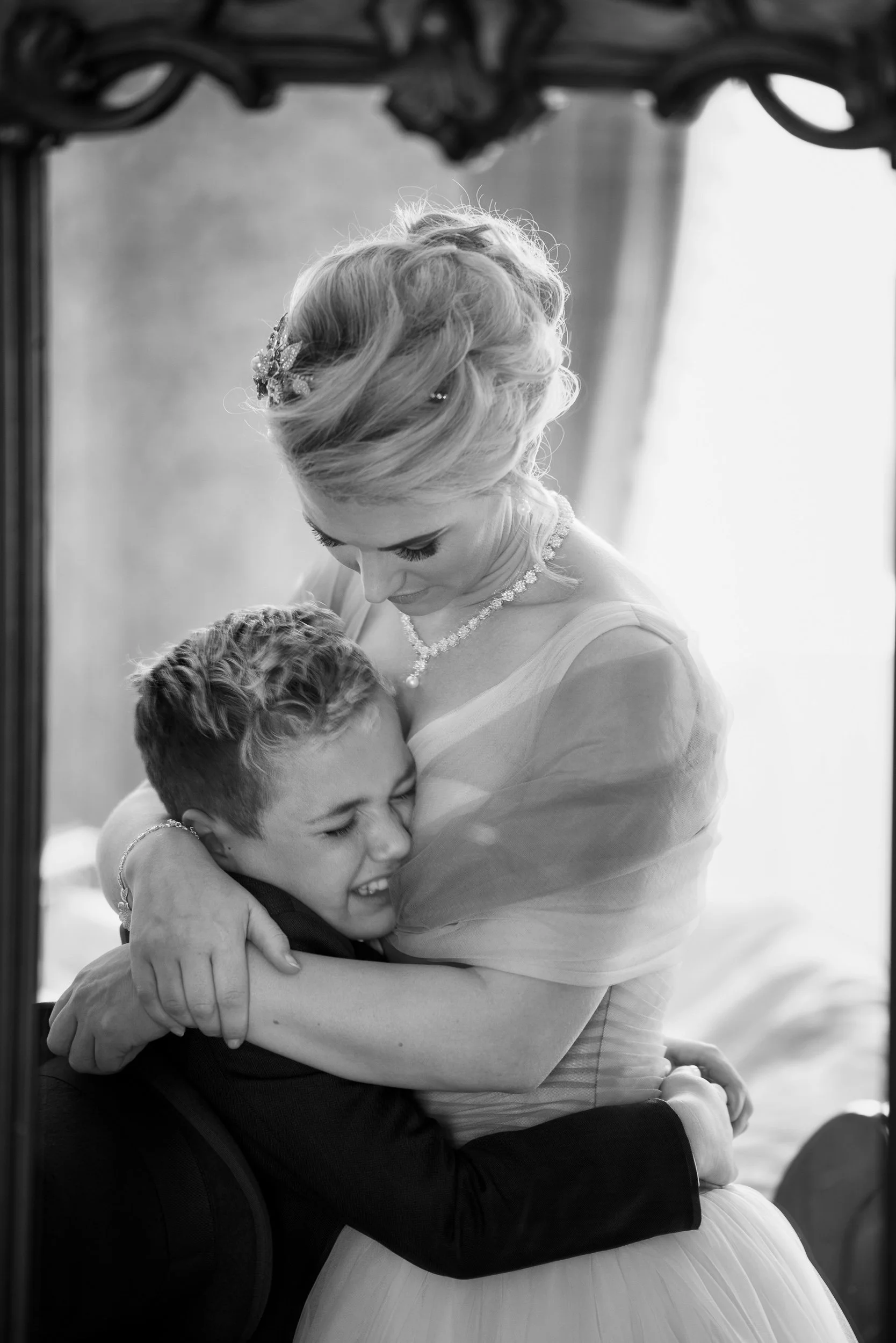 Wedding Photography Meath – emotional bride and son embrace in reflection at Boyne Hill House