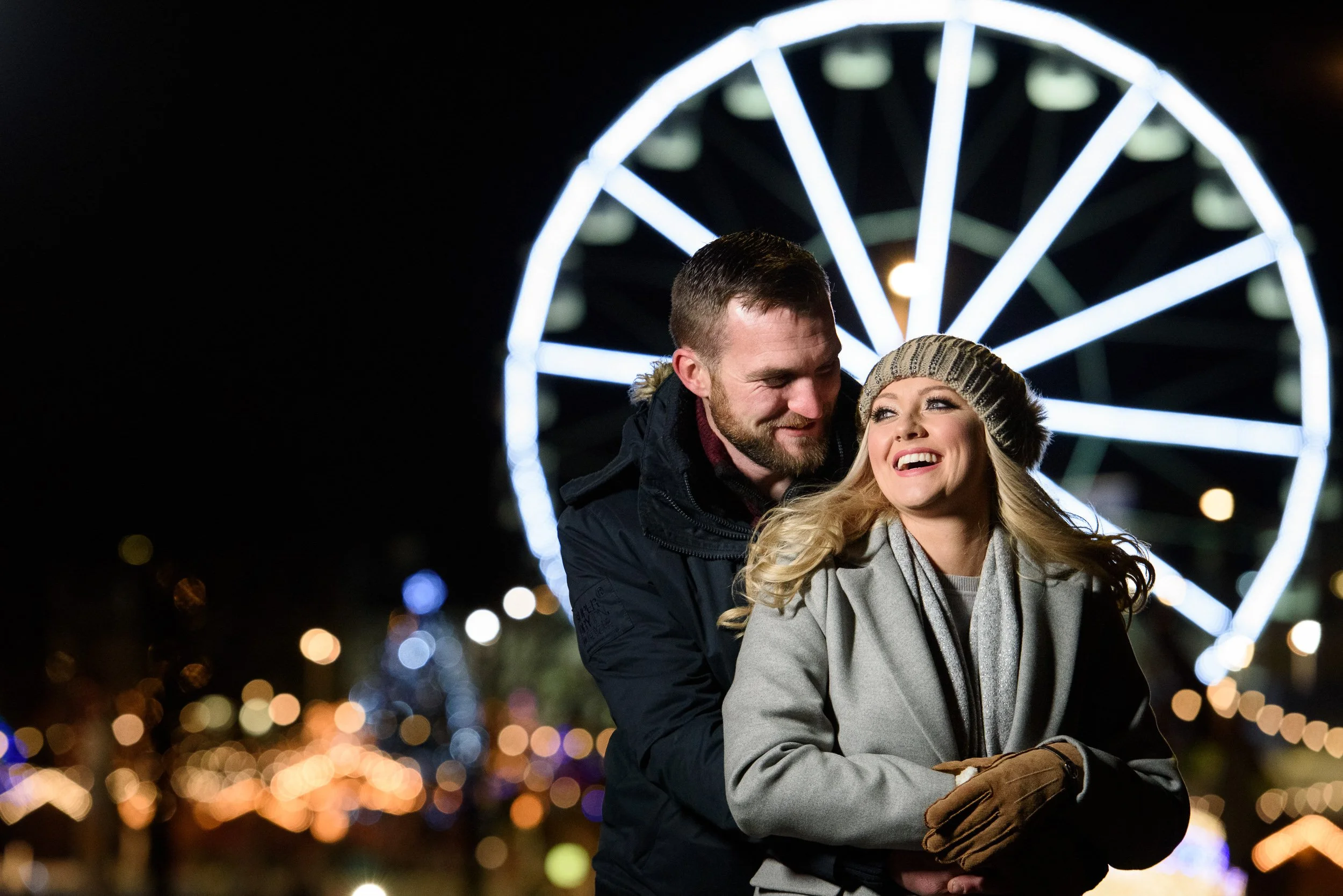 Engagement Photography Galway – couple at fairground with Ferris wheel at Eyre Square
