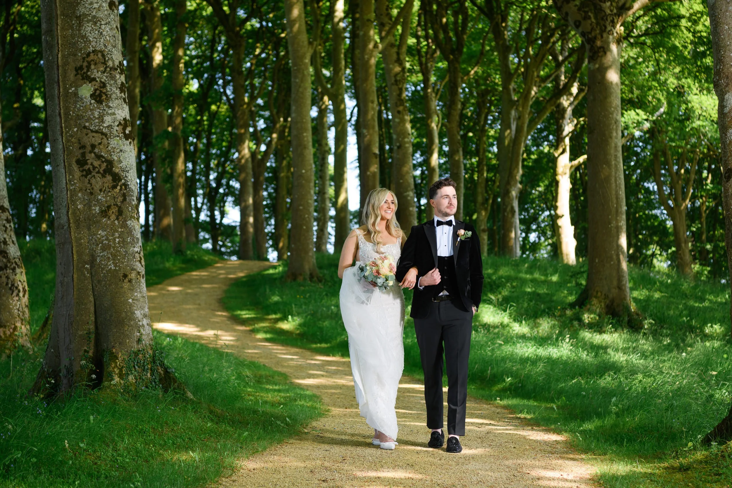 Wedding Photography Westmeath – couple walking through forest at Glasson Lakehouse