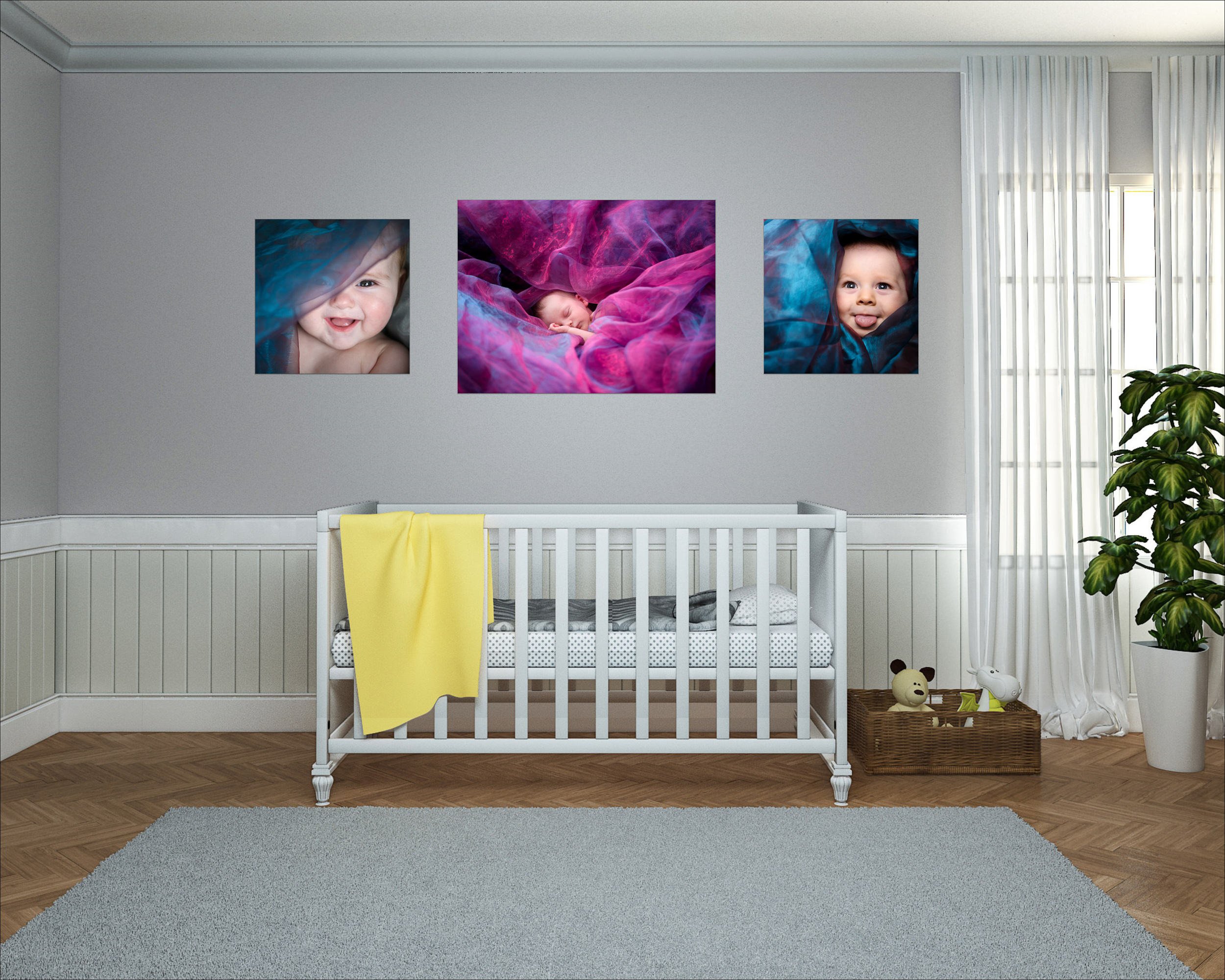 Baby crib in a nursery with three framed photos of a smiling baby on the wall, a wicker basket with toys, and a large plant near the window.