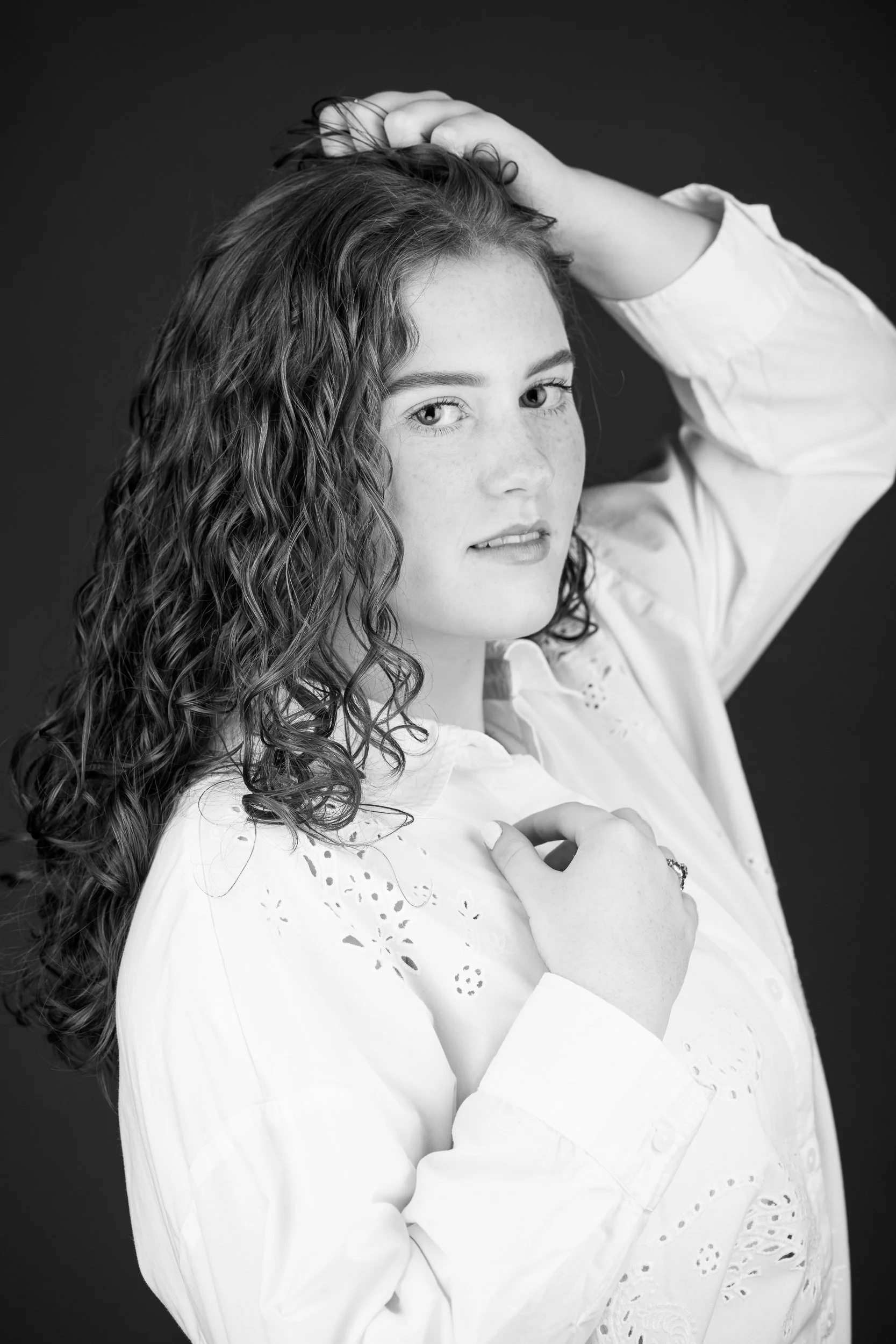 Black and white portrait of a woman with curly hair in soft directional lighting
