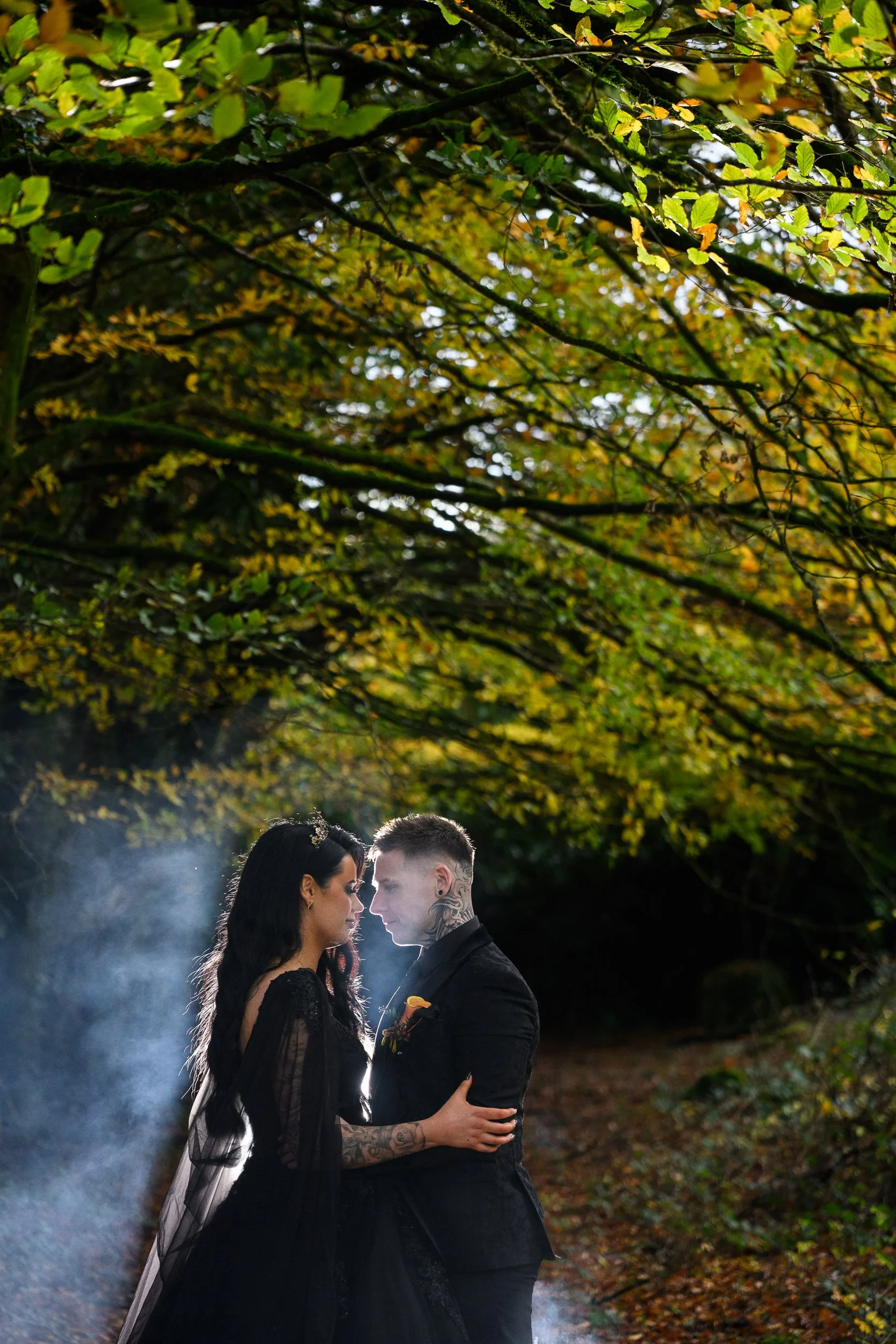 Wedding Photography Ireland – couple embracing outdoors in autumn forest with atmospheric smoke at Kinnitty Castle
