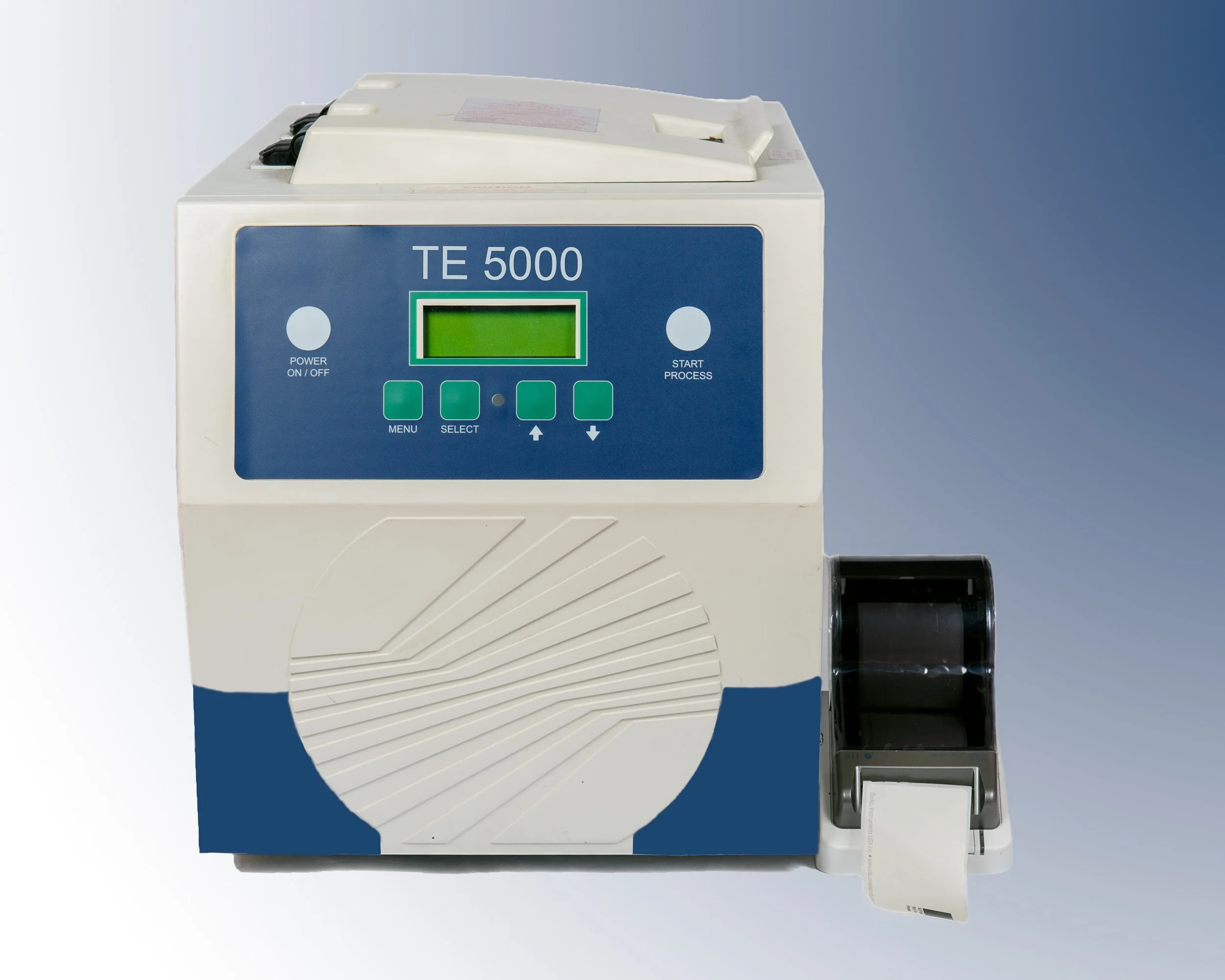 Laboratory analyser machine with digital display and printed output, photographed in a clean technical setting.
