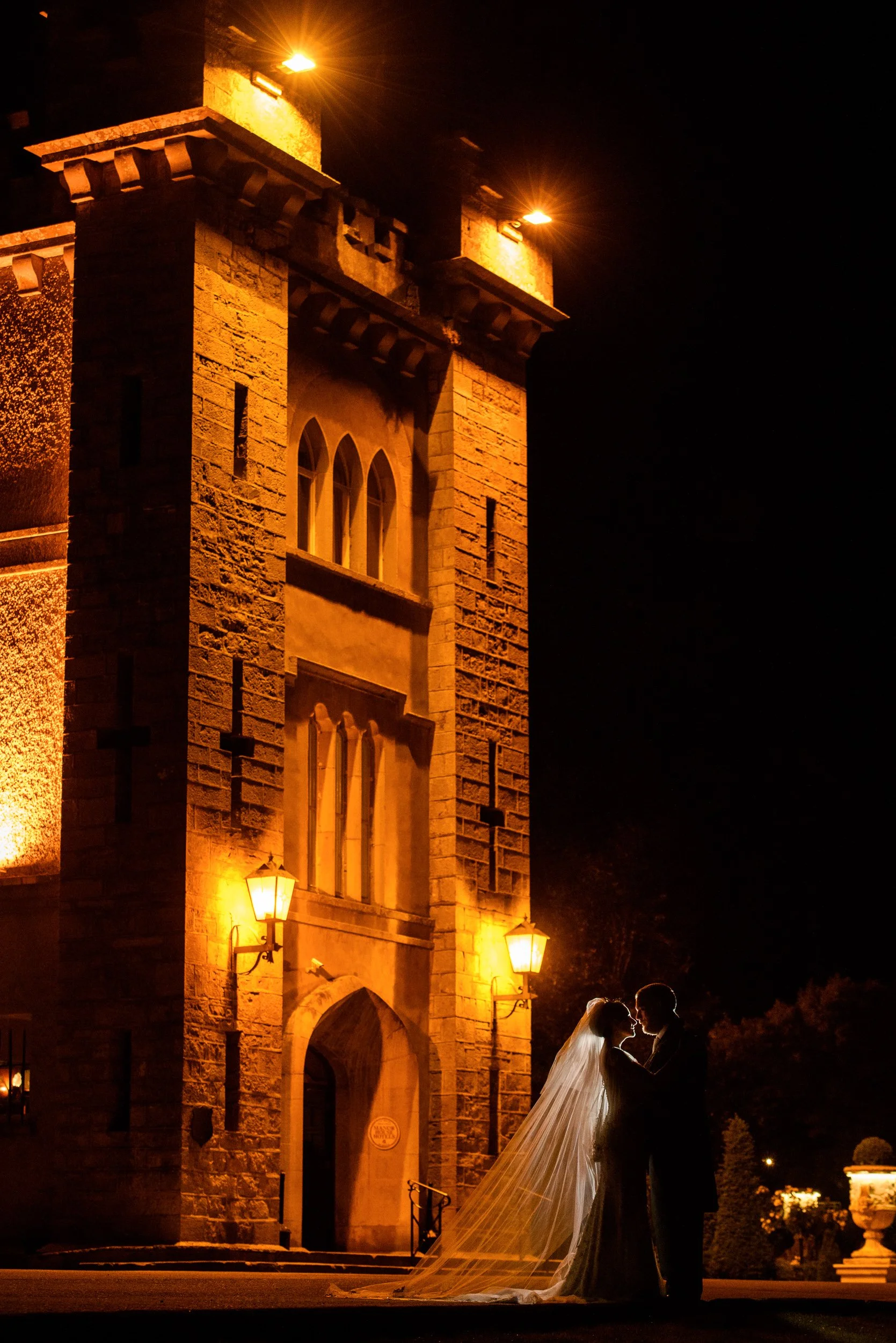 Wedding Photography Ireland – bride and groom silhouette at night with warm architectural lighting at Cabra Castle in Cavan