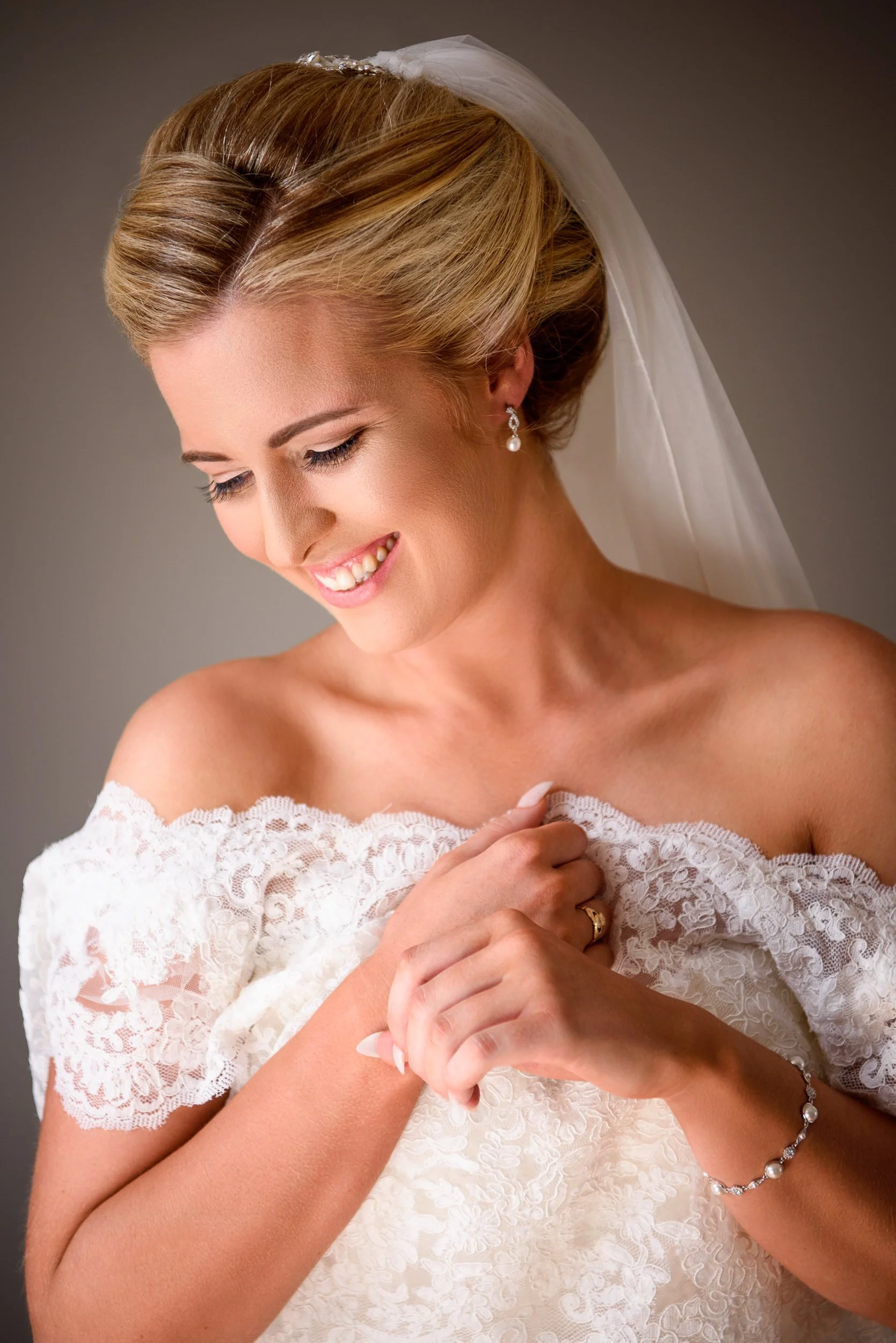 Wedding Photographer Ireland – bride portrait putting on her dress and elegant styling
