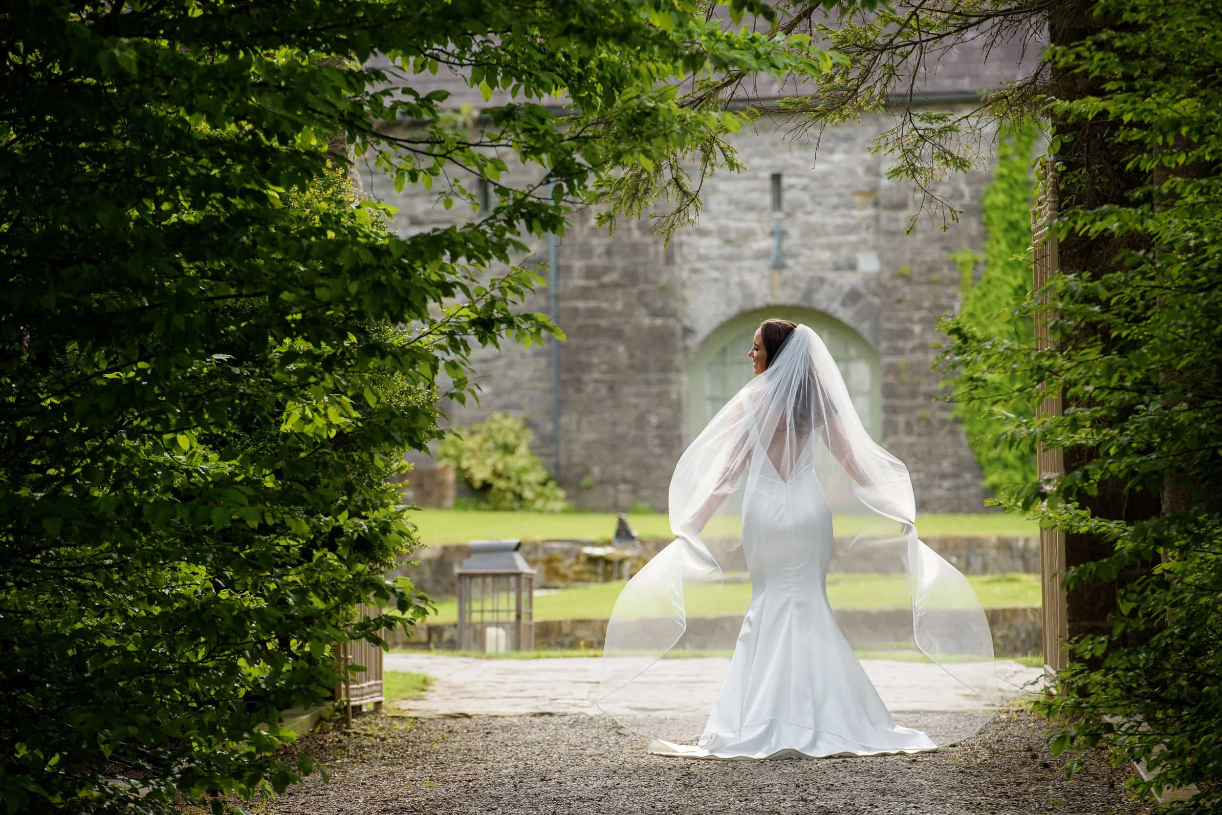 Wedding Photographer Ireland – bride portrait outdoors under garden arch at Ballymagarvey Village with natural light