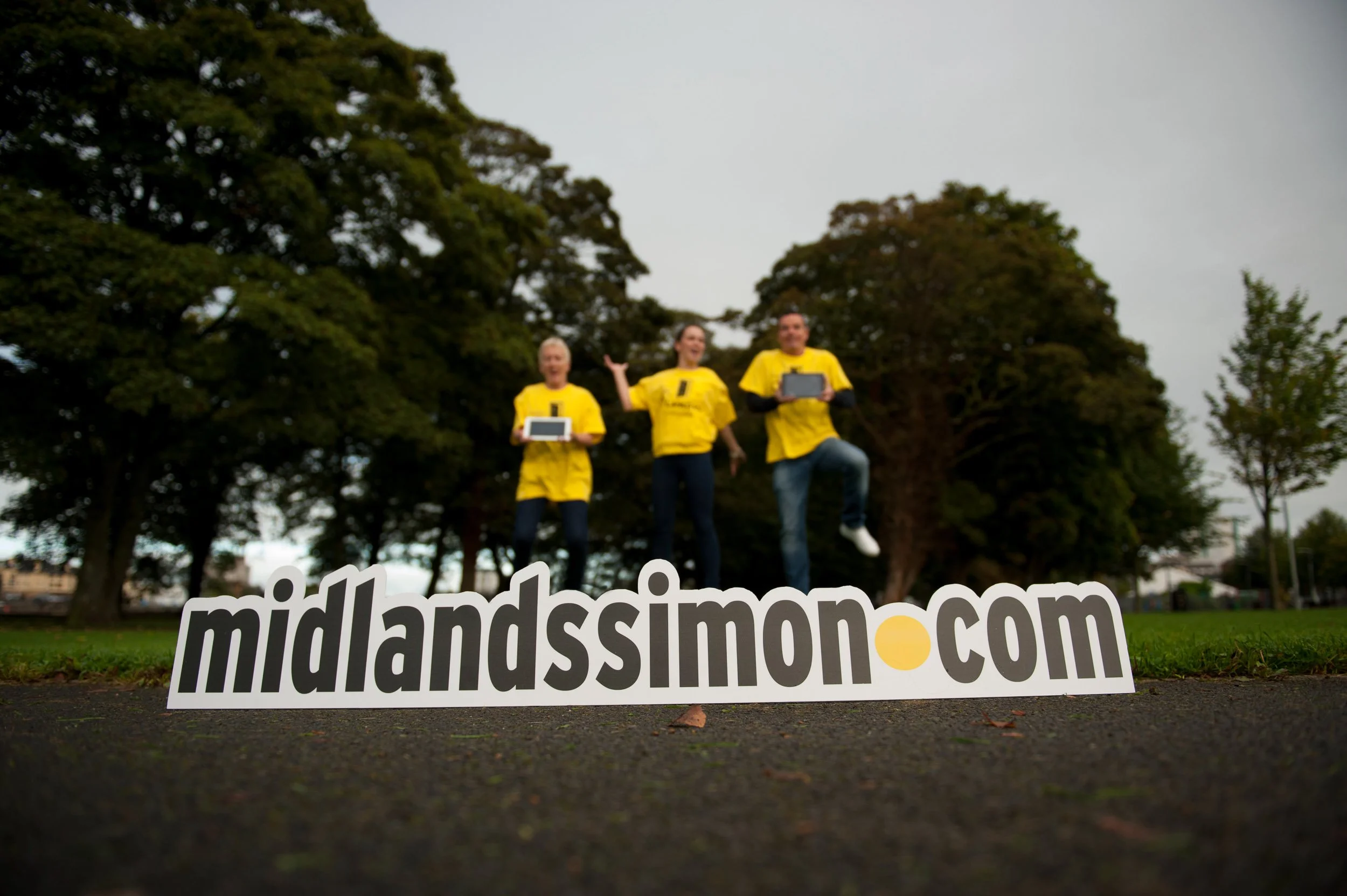 Group portrait of participants at a community event holding promotional materials.
