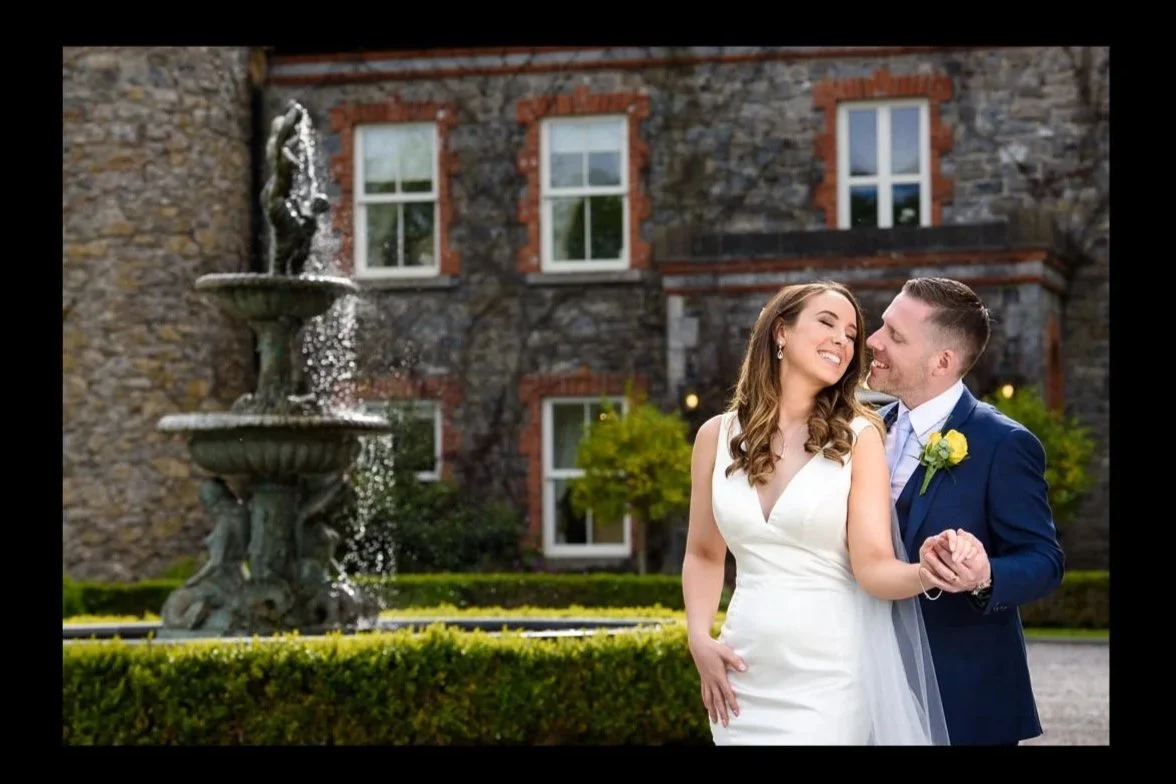 Wedding Photographer Ireland – bride and groom dancing by fountain at Ballymagarvey Village in Meath
