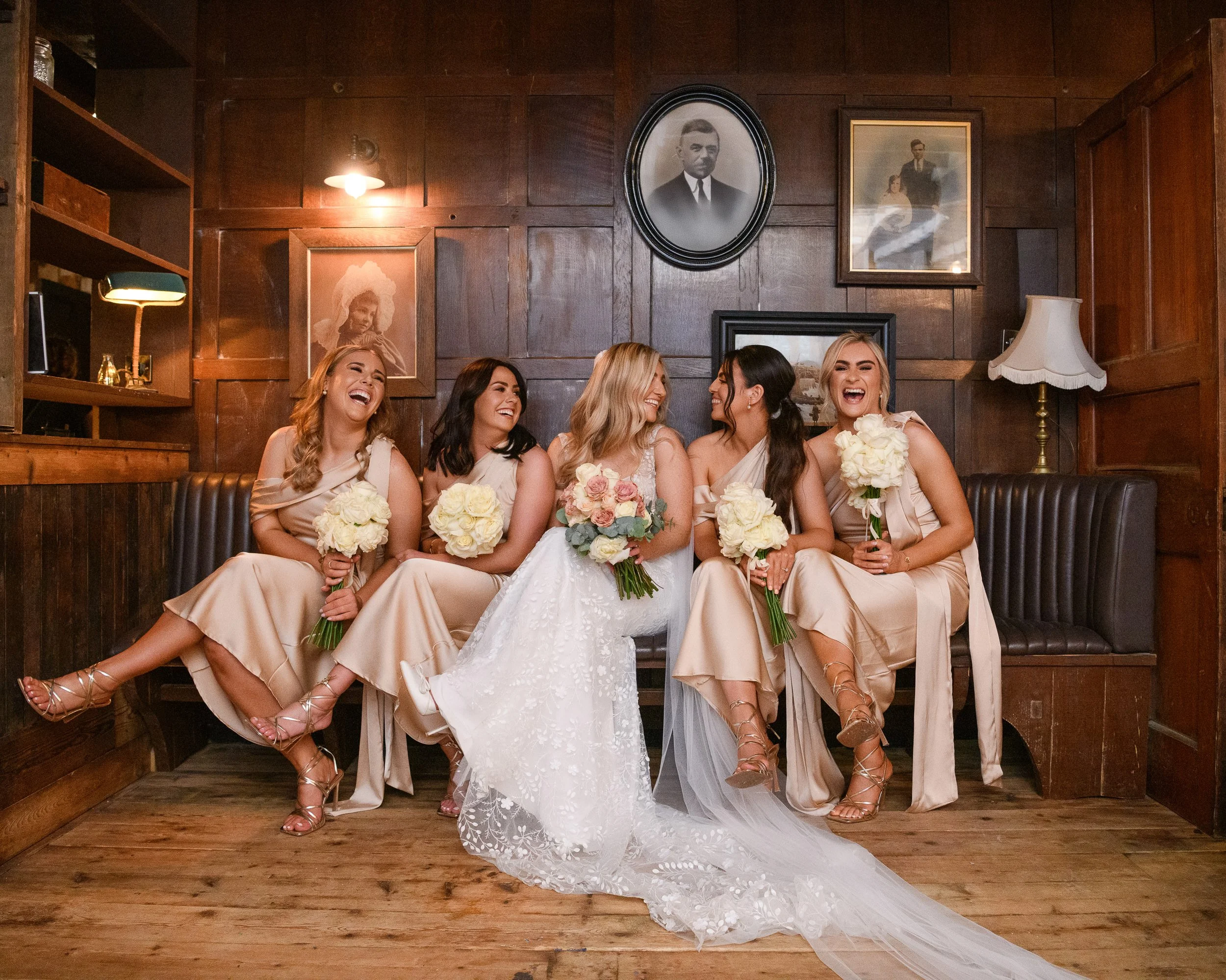 Wedding Photography Westmeath – bride and bridesmaids laughing with bouquets at Glasson Lakehouse