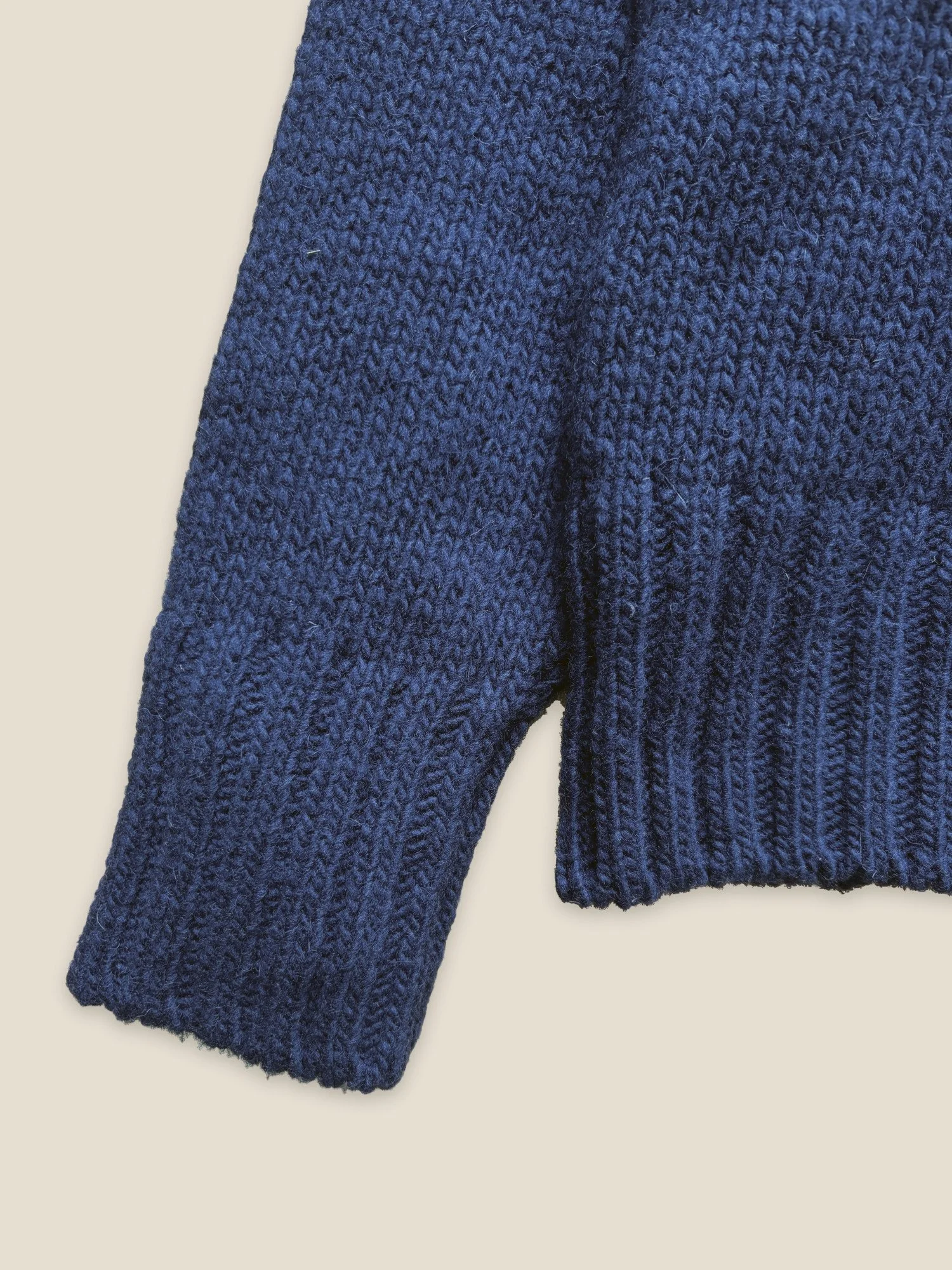 Close-up of the ribbed cuff and hem on the Floca Ringo Sweater in ink blue Spanish wool
