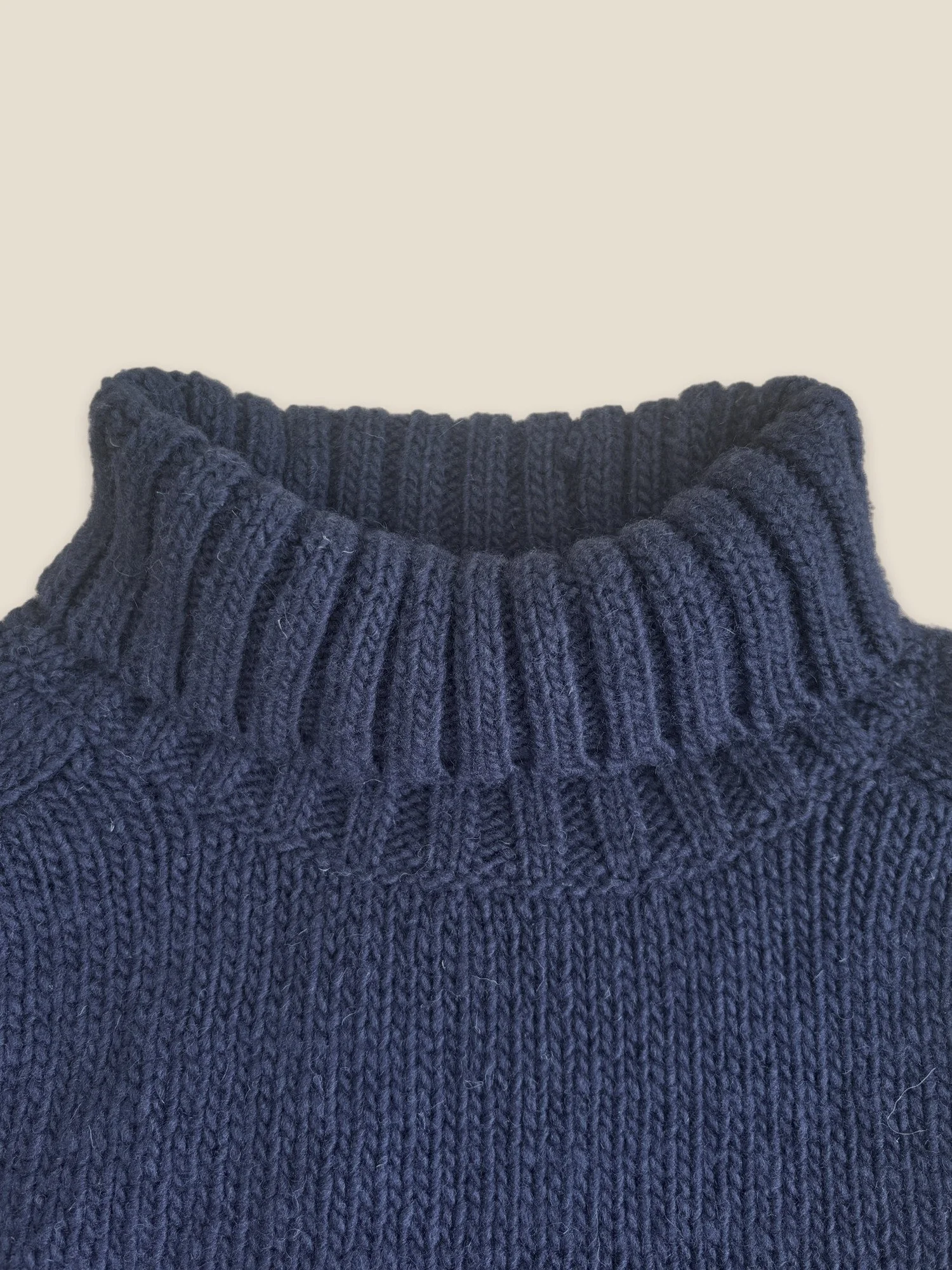 Close-up of the Ink Blue Ringo Oversize Sweater by Floca with the ribbed turtleneck folded down.