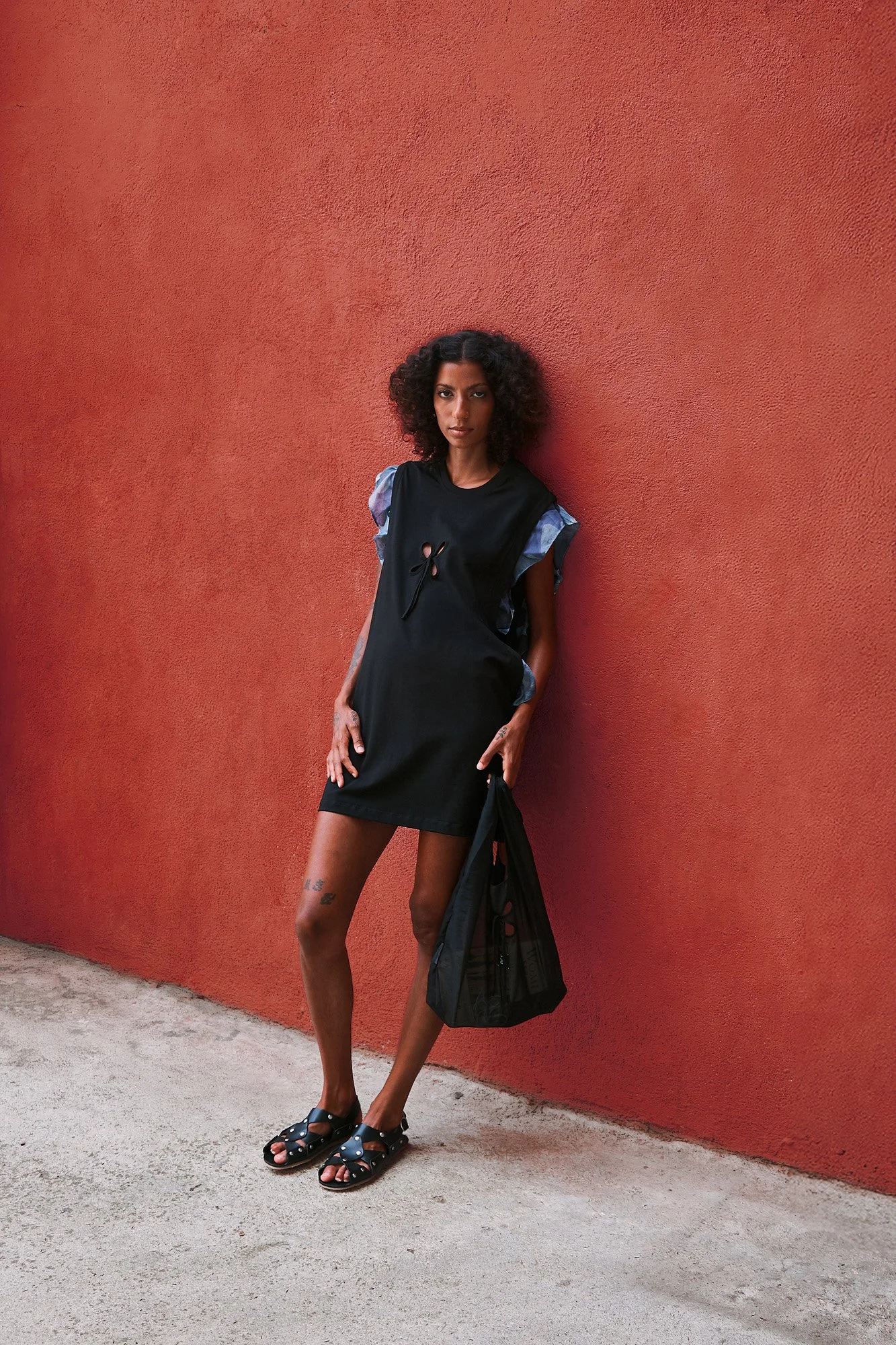 J.Kim Anechka petal t-shirt in black, full-length front view showing the blue floral ruffle sleeves and petal cut-out, styled with Cordoa black sandals
