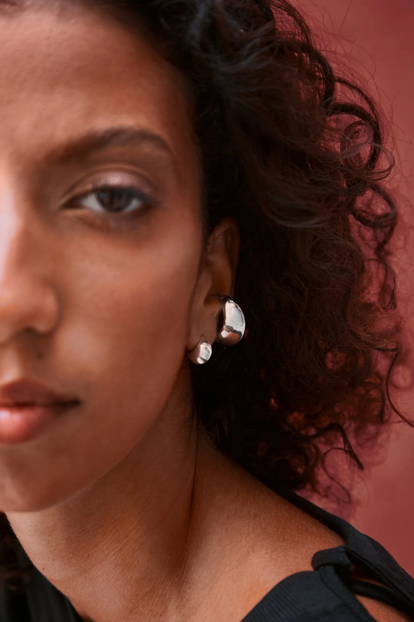 Florence Moorhead Petite Lune earring in silver, close-up of the small sculptural stud earring worn on the ear