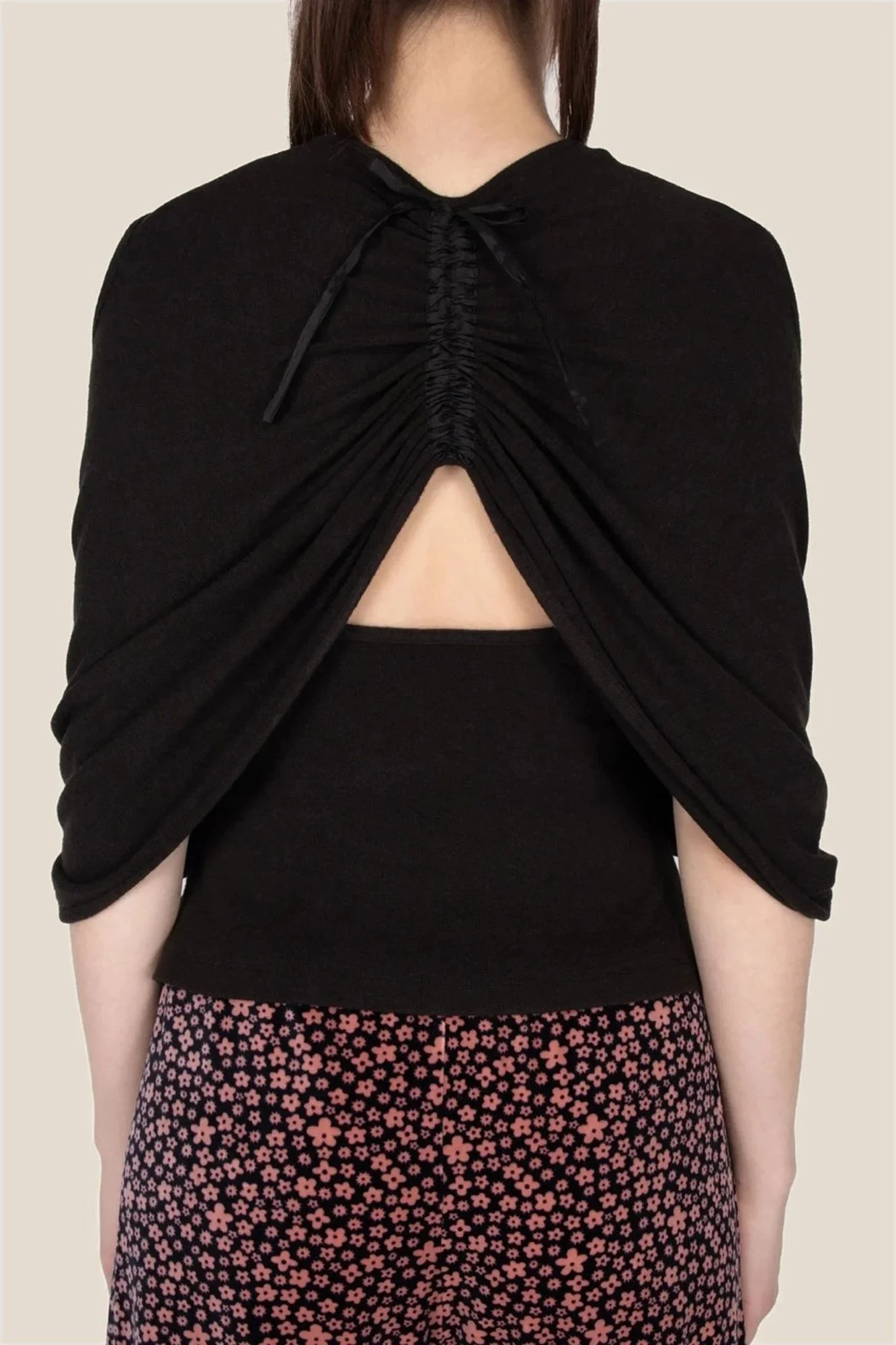 Detail of back of J.Kim sleeveless halter knit top in black with an attached shawl draped over the shoulders