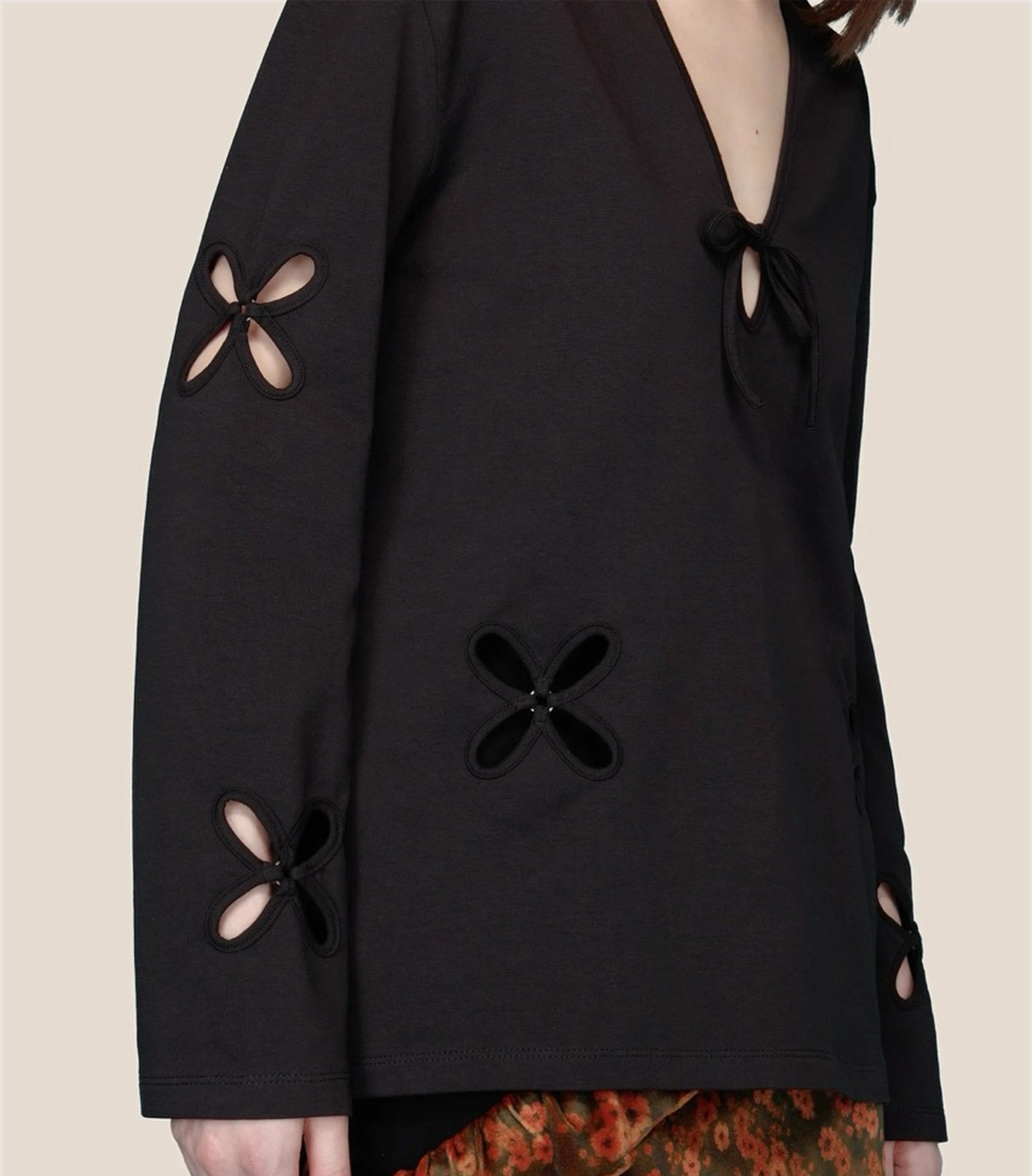 J.Kim black cotton jersey tunic, side view showing petal cutouts on the sleeve and body and the hem
