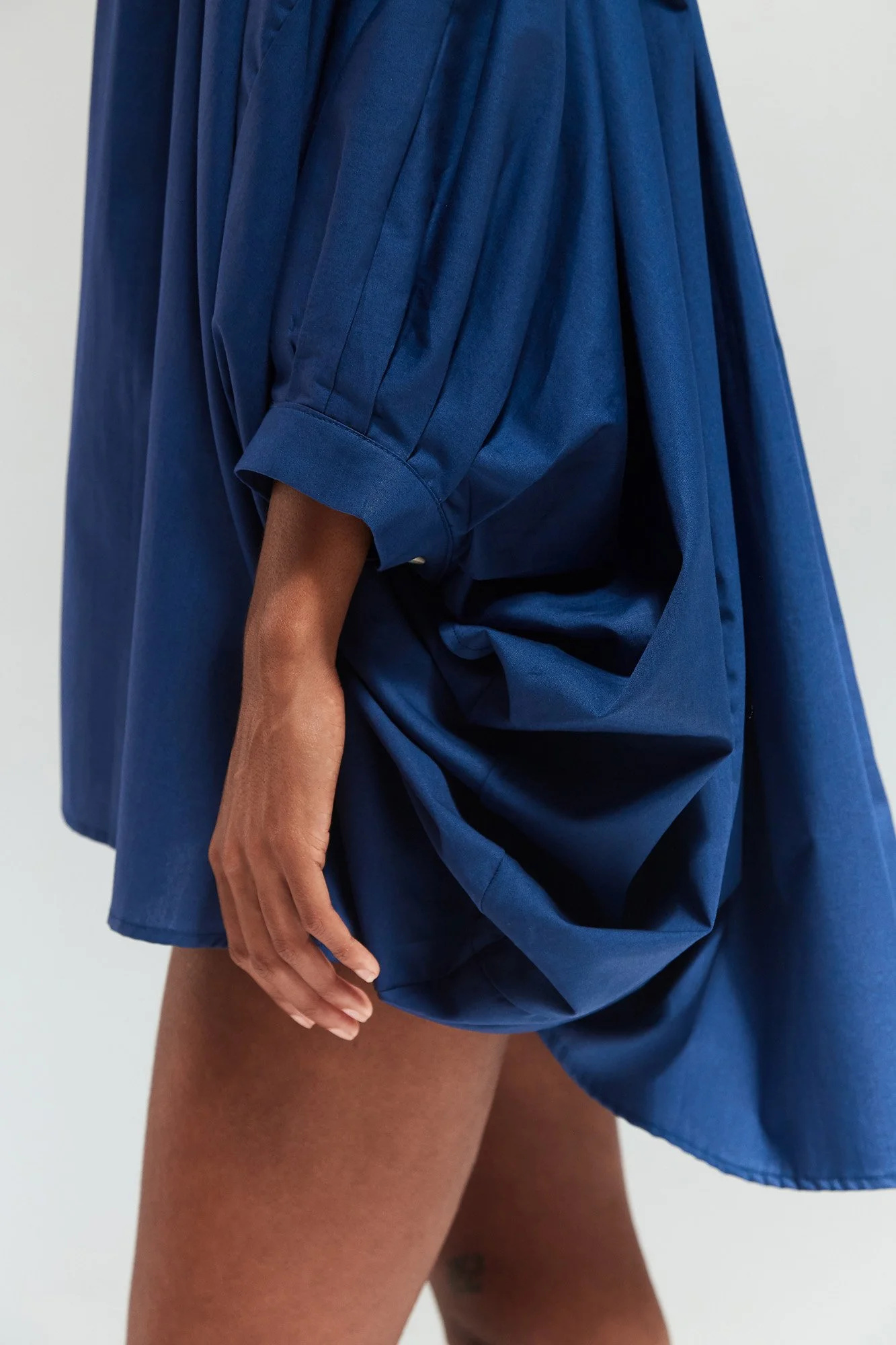 Intellectual Leisure Stella top in blue, close-up of the draped hem and cuffed elbow-length sleeve
