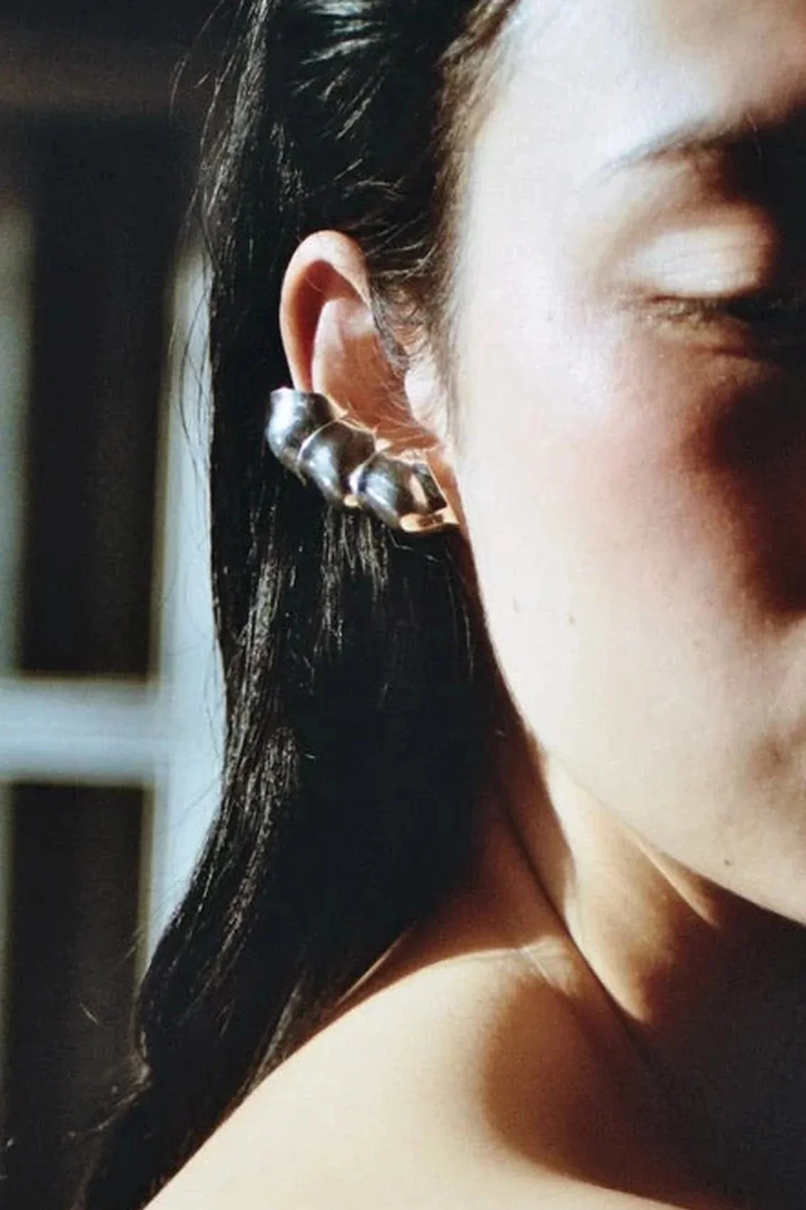 Anicet Goutte Ear Cuff worn as a stack of three along the ear, polished silver against dark hair